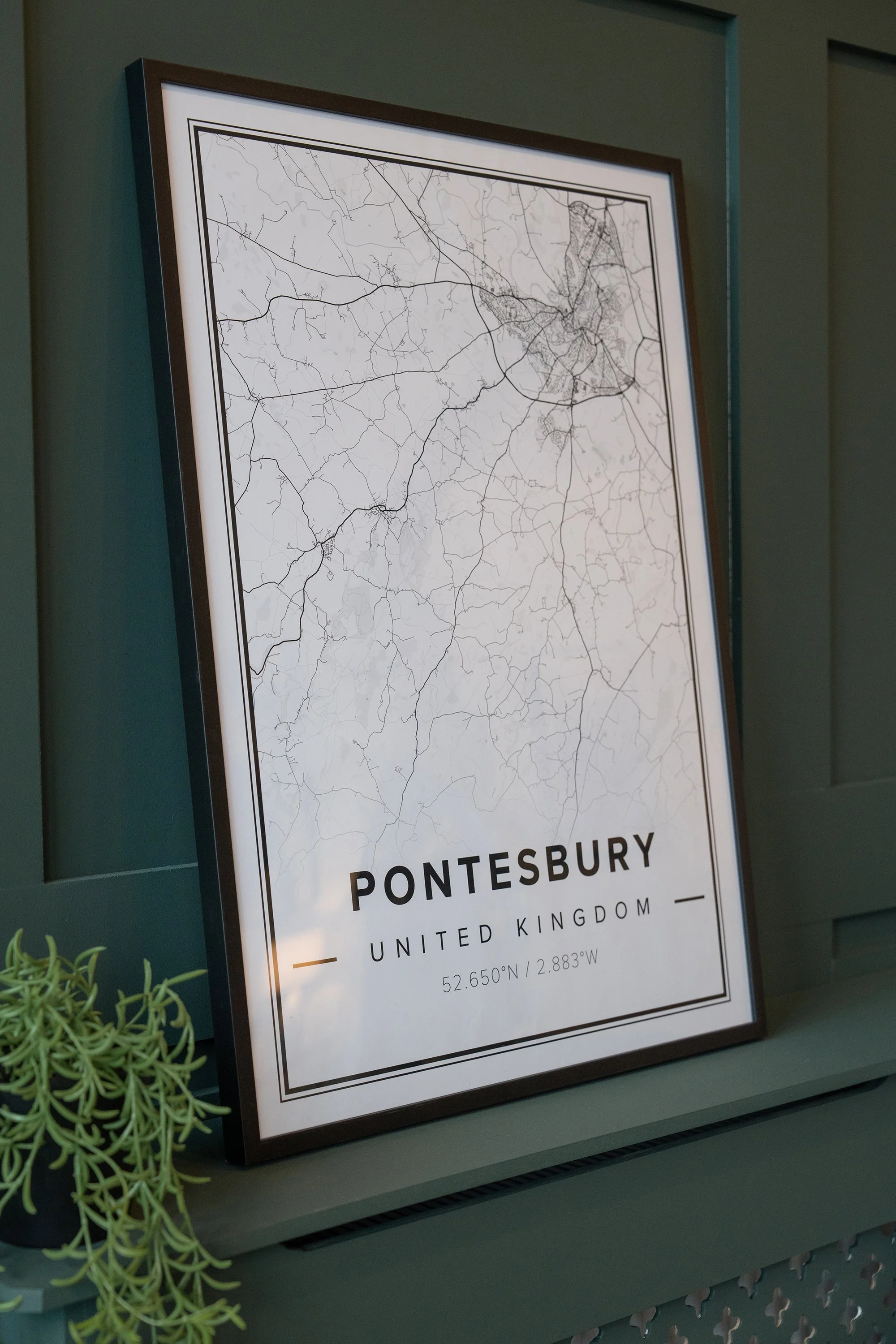 Framed local map artwork styled against dark green panelling in the Grantham's Estates office, adding personality and a strong sense of place.