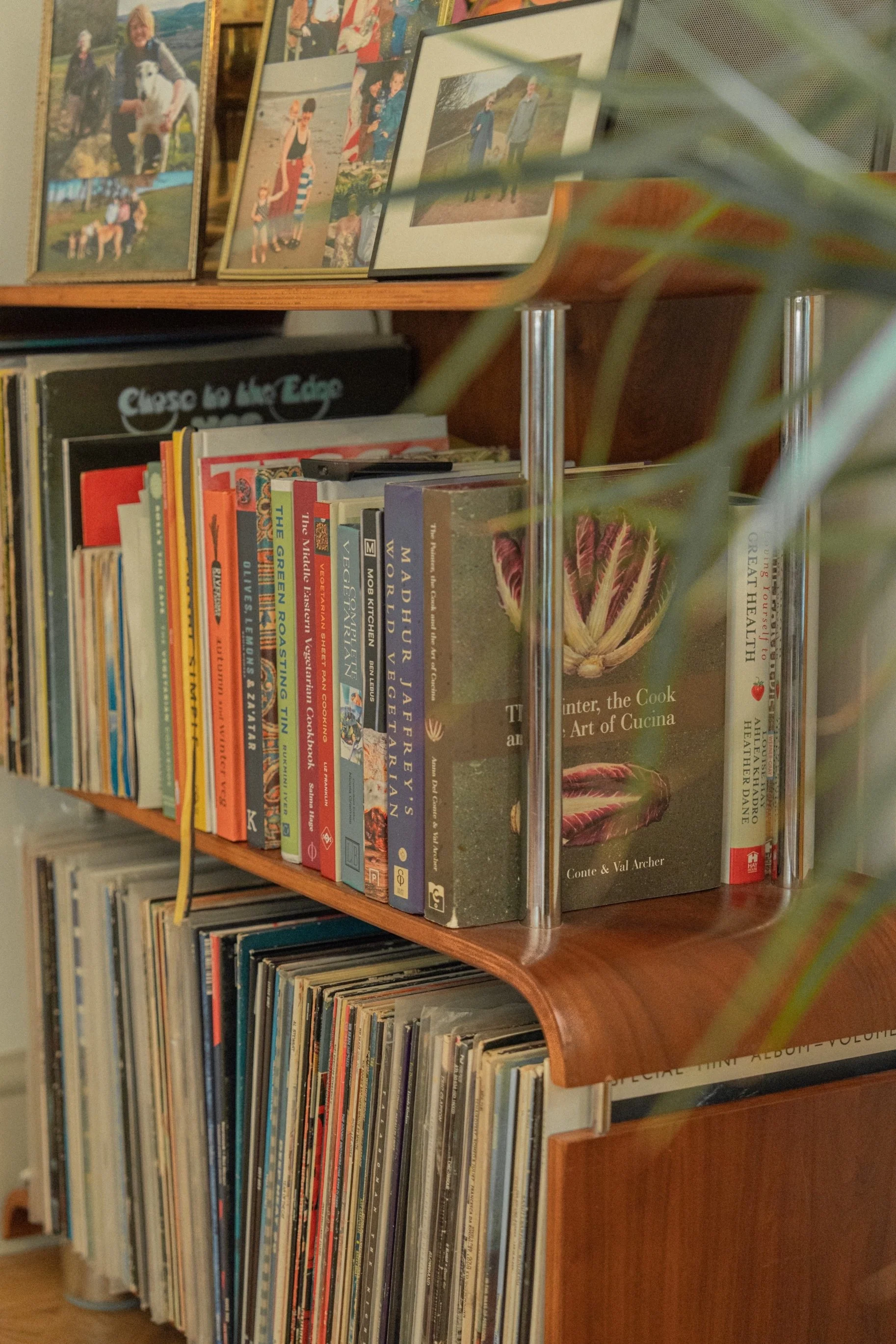 Curated bookshelf styling with vintage books, collected artwork, and warm timber shelving in a cozy Edwardian family home.
