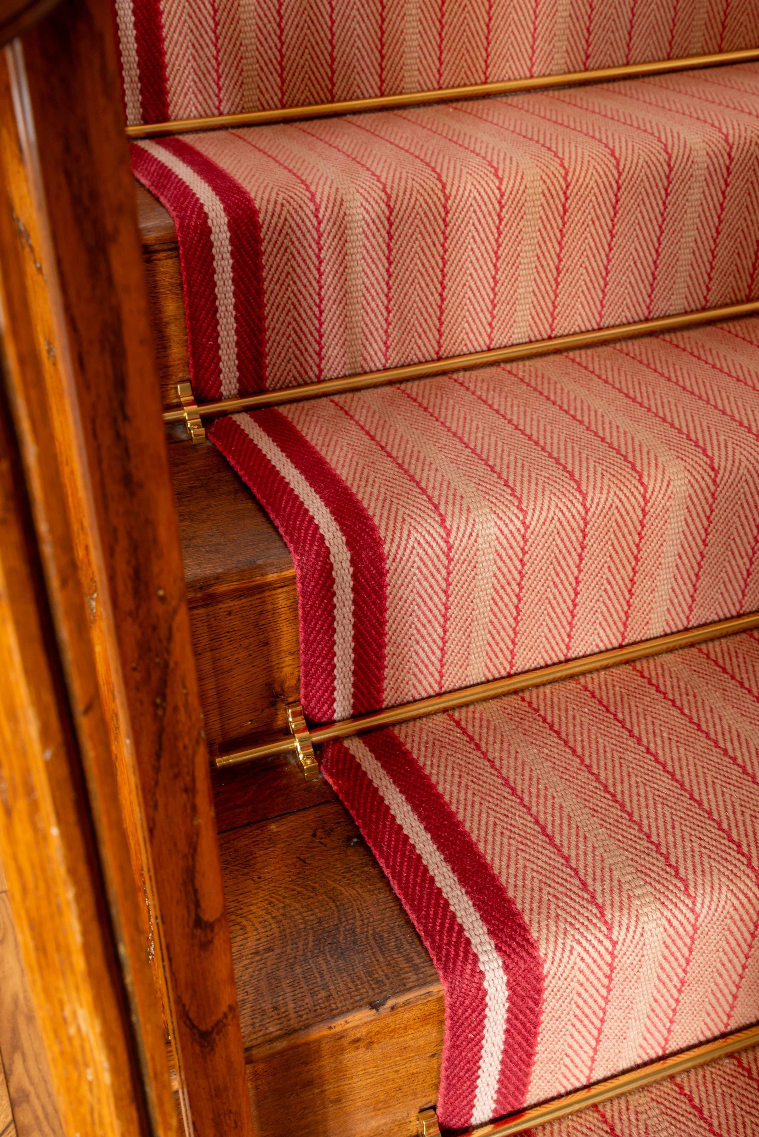 Traditional striped stair runner on original timber staircase adding warmth, texture, and heritage character to a Georgian country home.