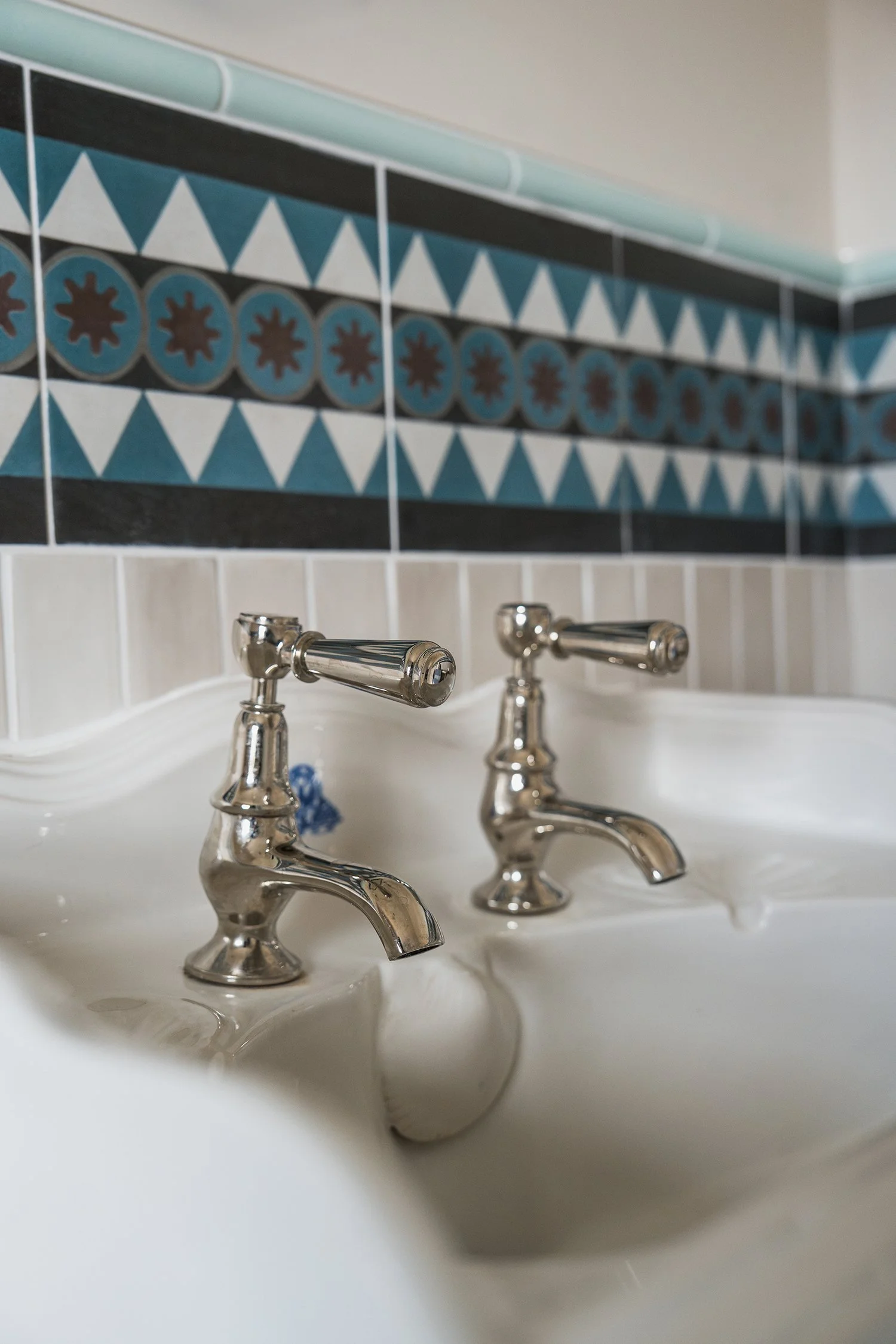 Classic chrome bathroom taps and geometric tile detailing in a thoughtfully designed townhouse bathroom interior.