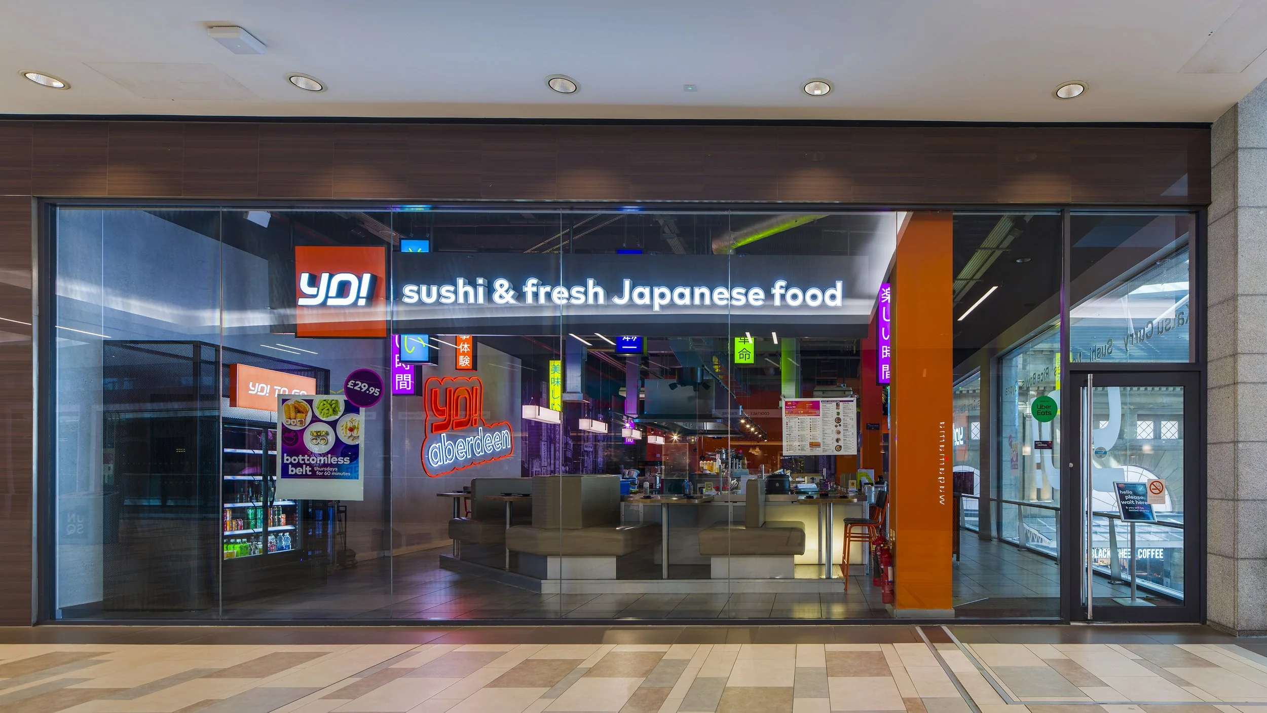 Modern sushi bar seating with warm ambient lighting and vibrant Japanese-inspired interiors at YO! Aberdeen restaurant.