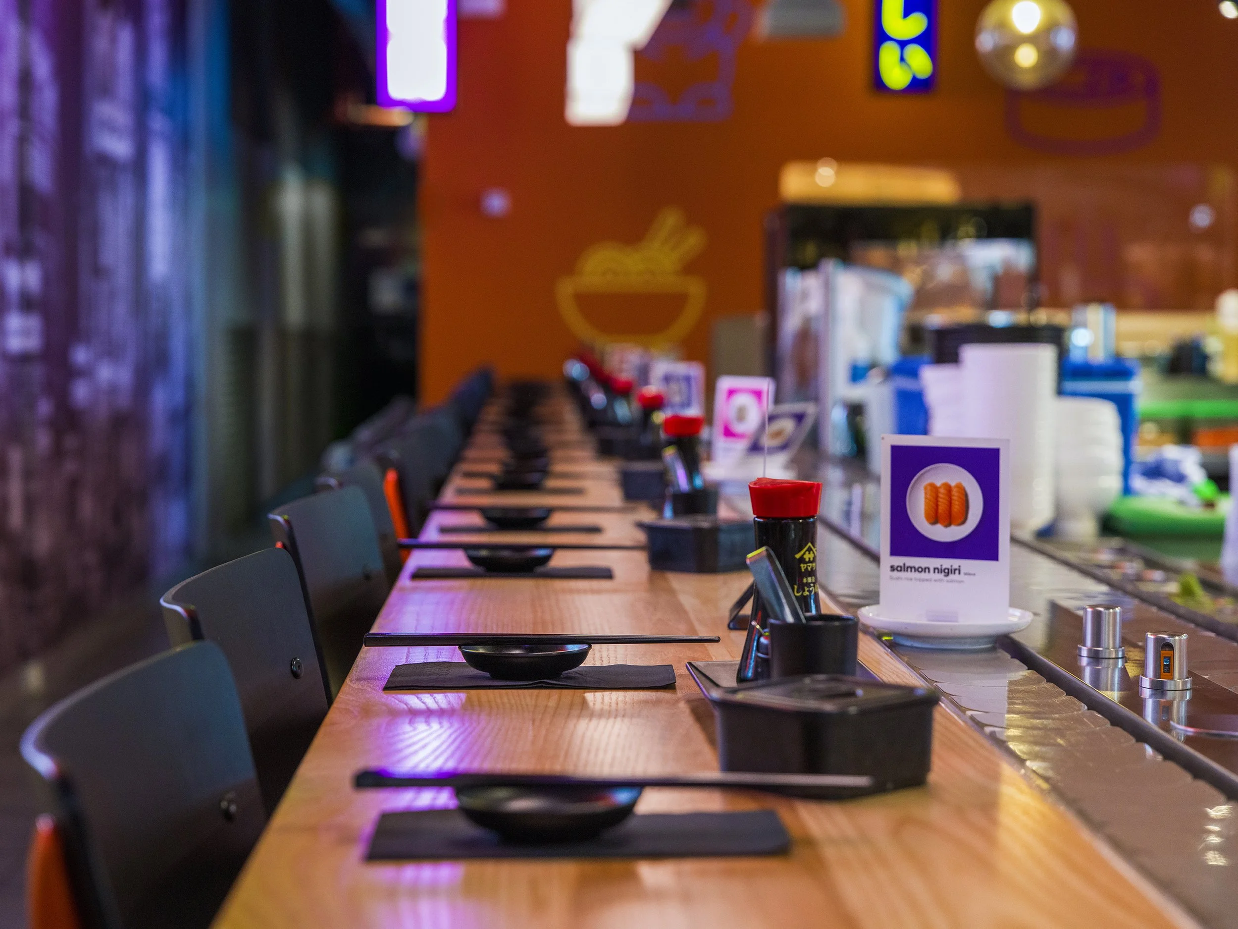 Neon YO! Aberdeen wall signage with contemporary sushi bar seating and urban-inspired restaurant interiors.