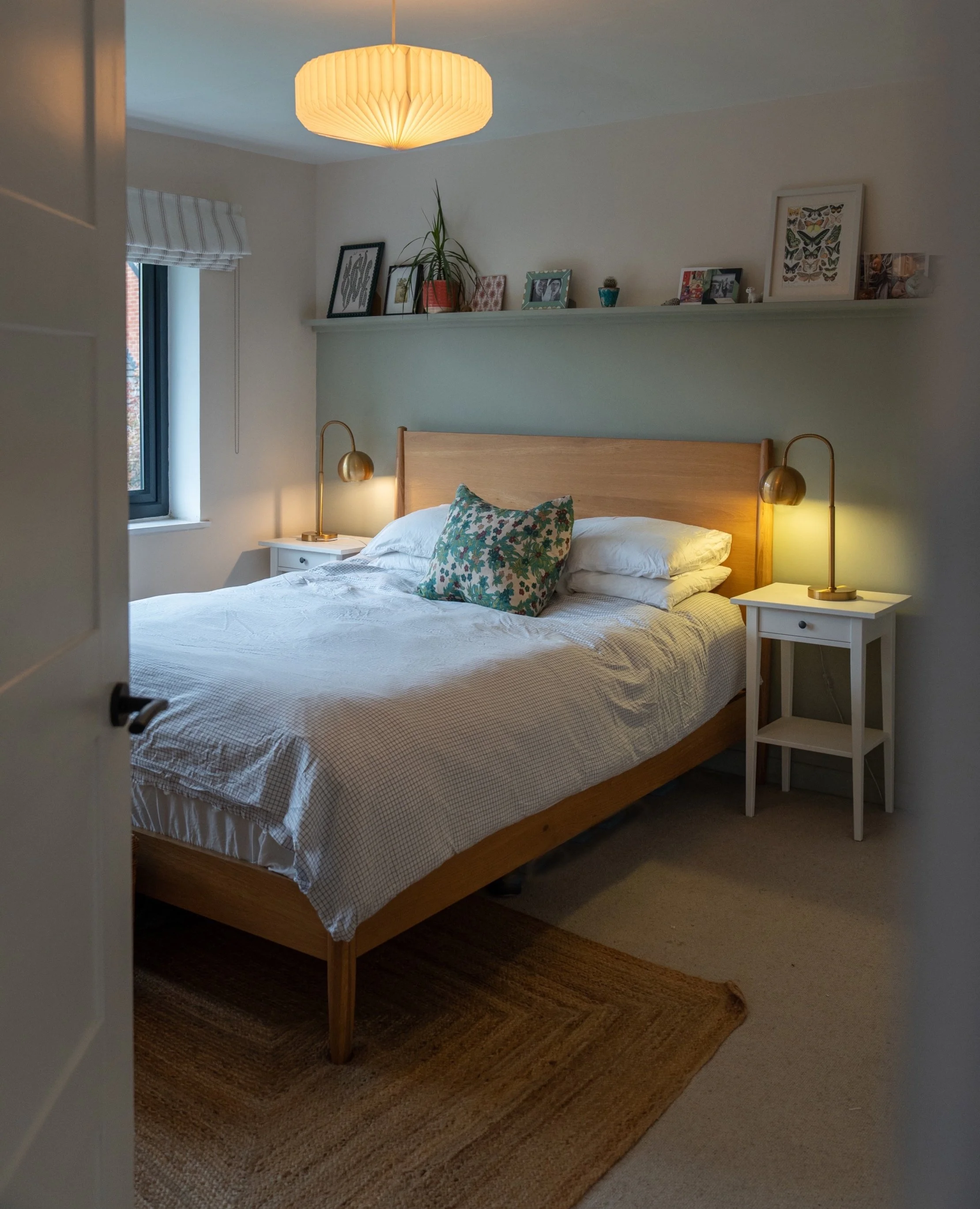 Cozy modern bedroom with upholstered bed, soft neutral decor, bedside lighting, and Scandinavian-inspired interior styling.