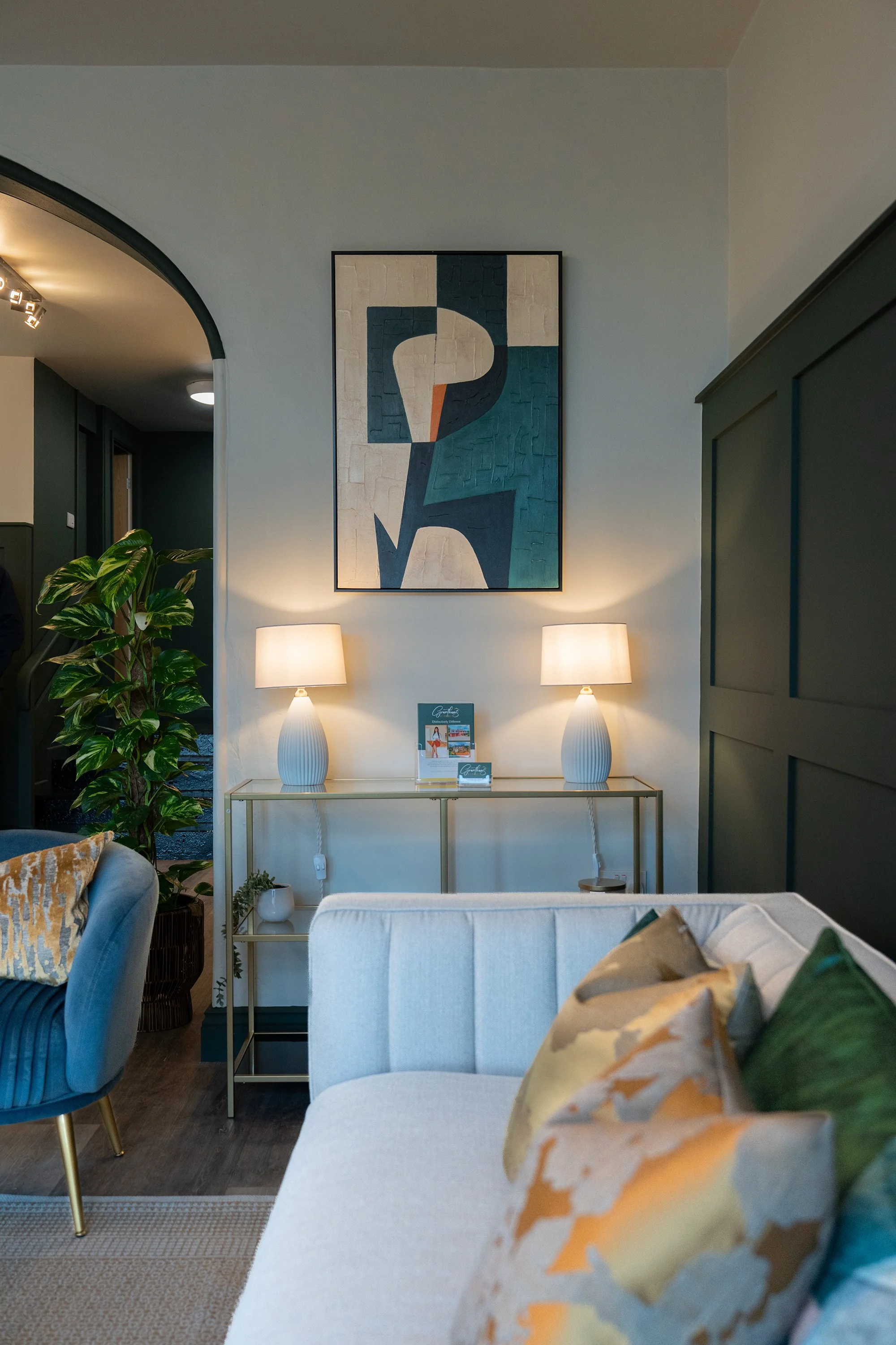 Contemporary estate agency office interior with bespoke wall panelling, abstract artwork, and elegant styling designed for a premium customer experience.