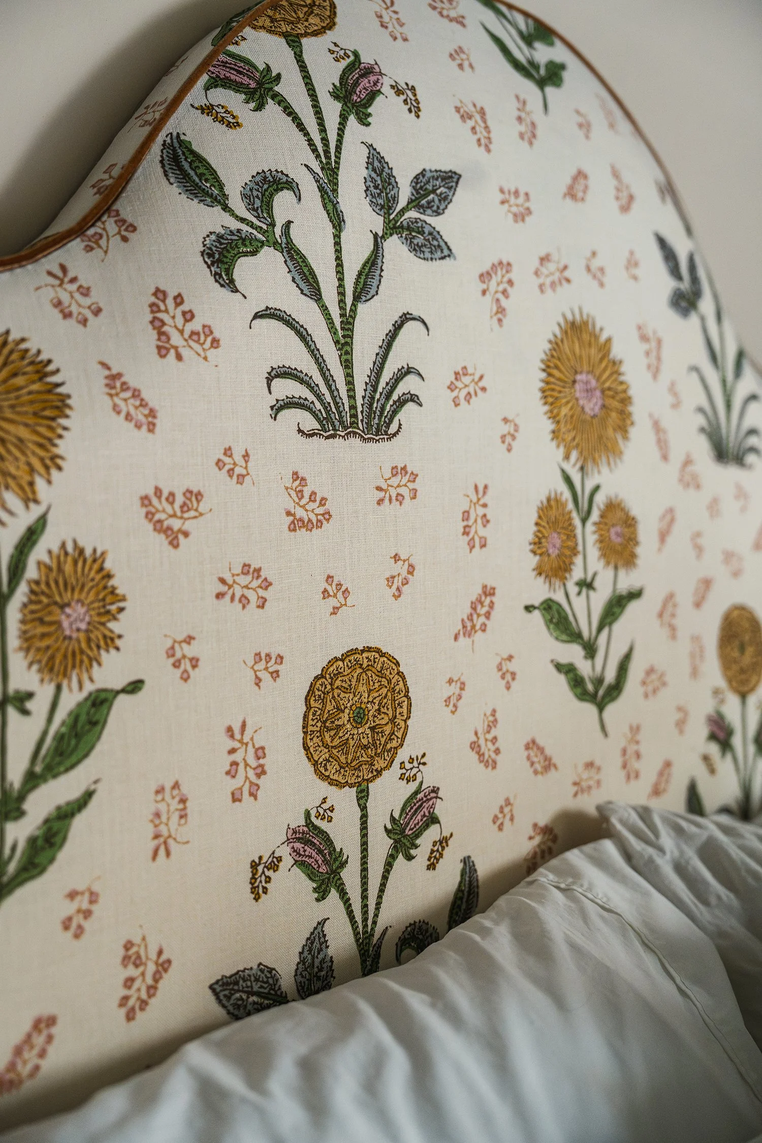 Floral upholstered headboard with delicate botanical fabric bringing softness and timeless charm to a townhouse guest bedroom.