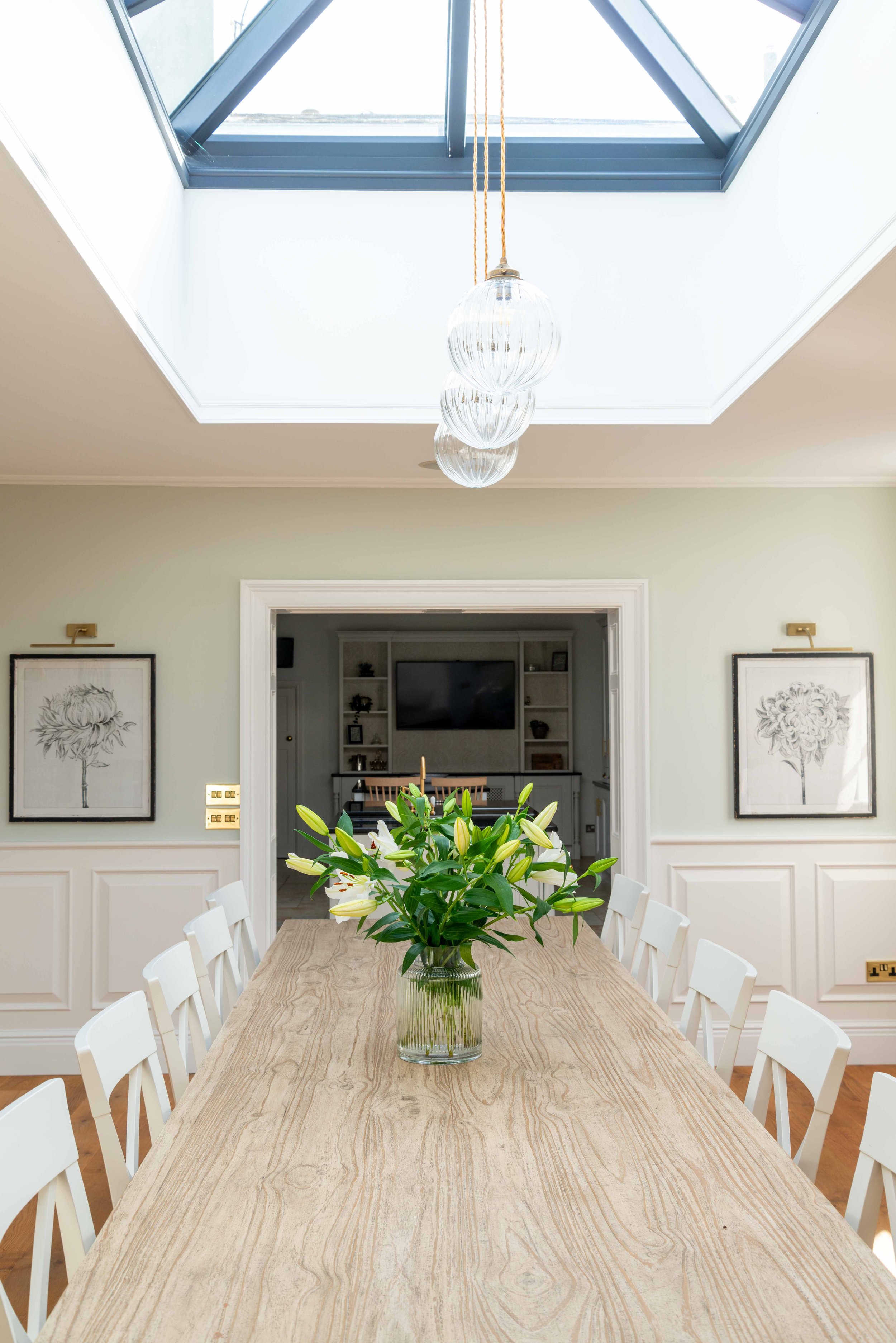 Bright Georgian dining room with large skylight, long wooden dining table, and soft neutral cabinetry creating a timeless family gathering space.