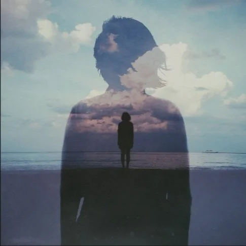 Lady standing on the beach with over lay of another women with her hair blowing in the wind