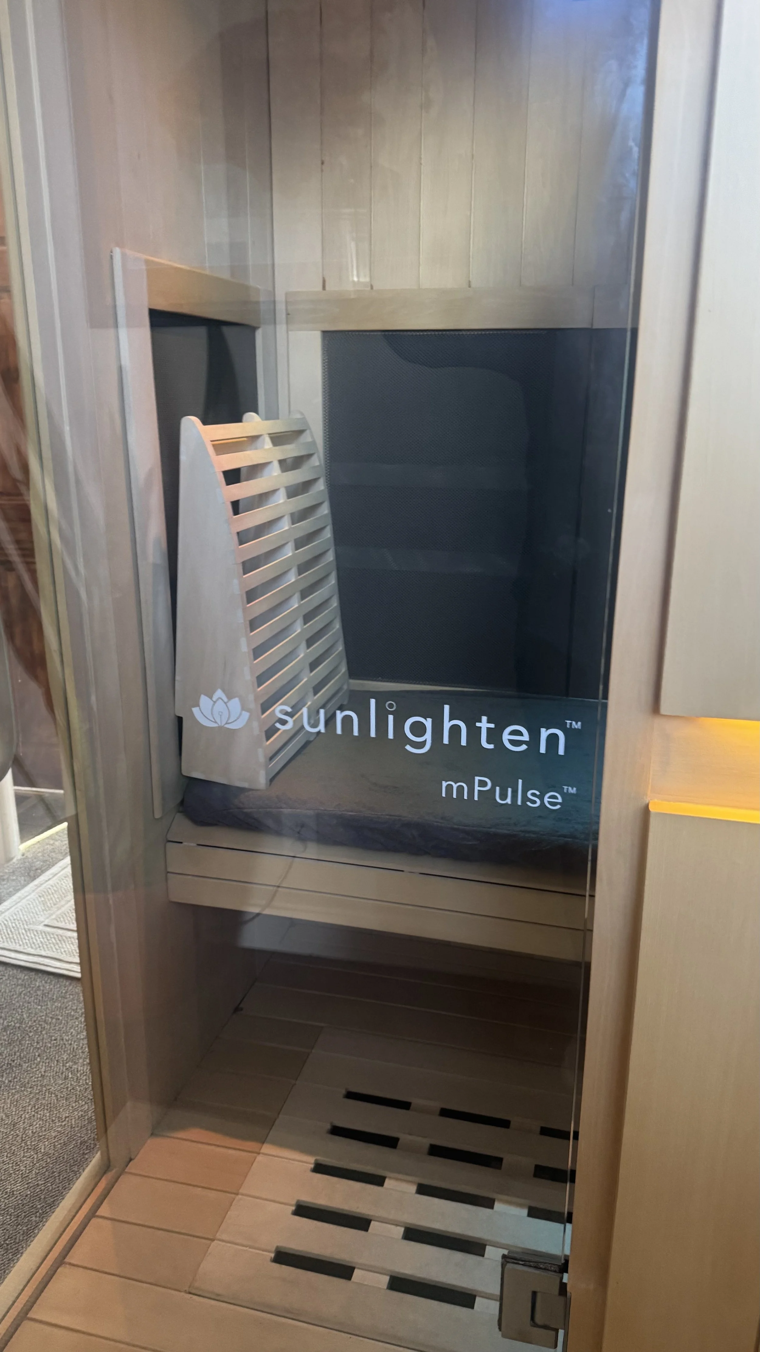 A sauna stove with hot stones emitting steam in a wooden sauna room.