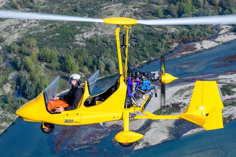 Flying a M22 over a river and forested landscape.