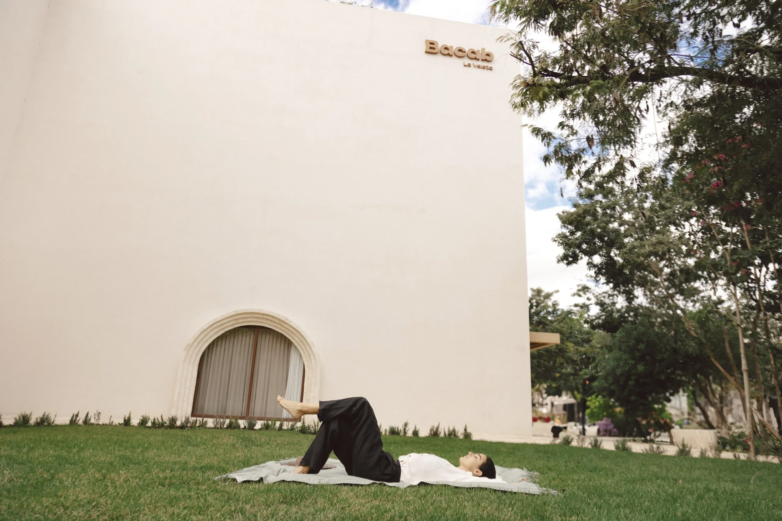 Woman lying on grass in the garden of Bacab Tulum boutique hotel