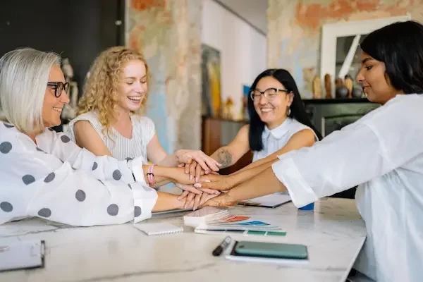 group-of-4-women-different-ages-putting-hands-together-as-a-pack