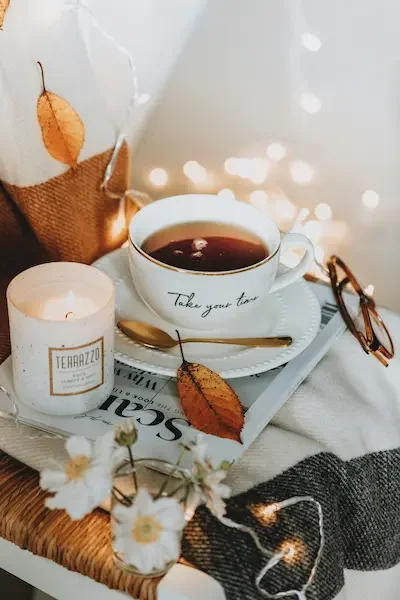 candle-tea-cup-lights-leaves-on-a-magazine