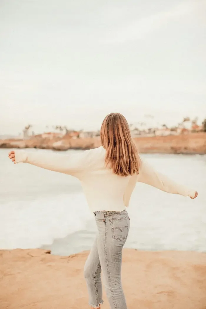 backview-of-a-female-on-beach-with-arms-open
