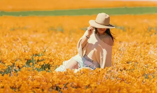 female-sitting-in-a yellow-flowerfield