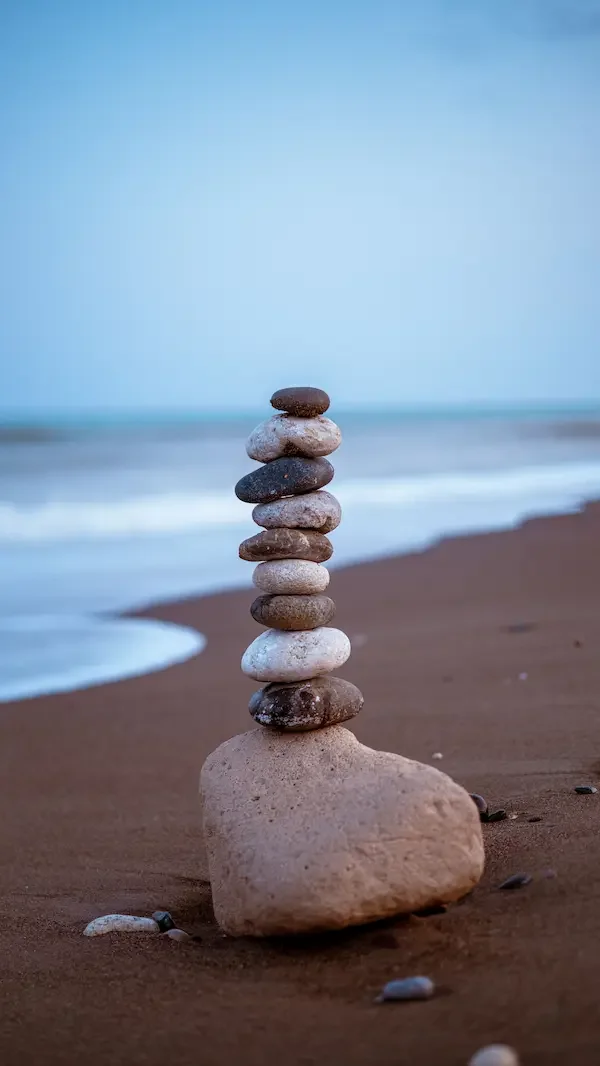 heart-shaped-stone-on-beach-sand-with-9-other-small-rocks-piled-on-top