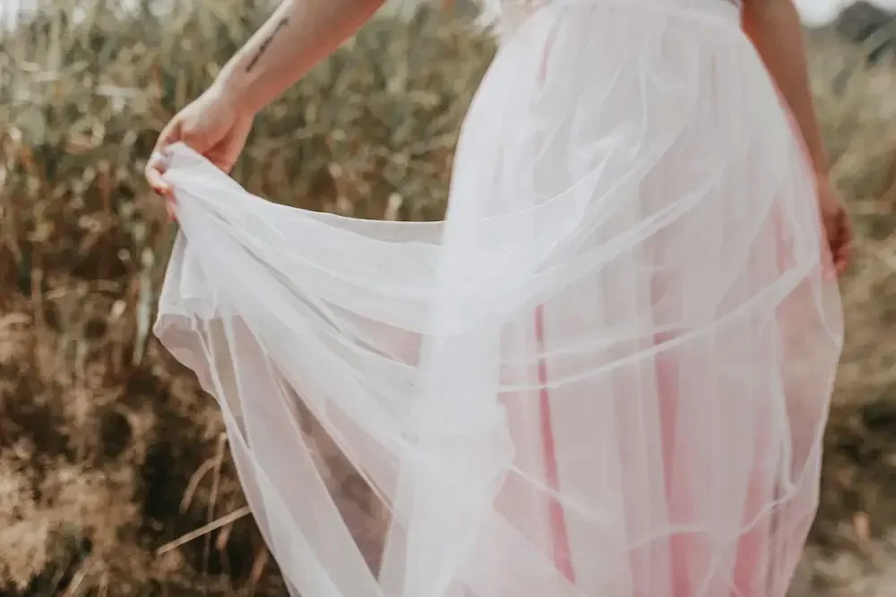female-wearing-pink-dress-holding-dress-with-hand