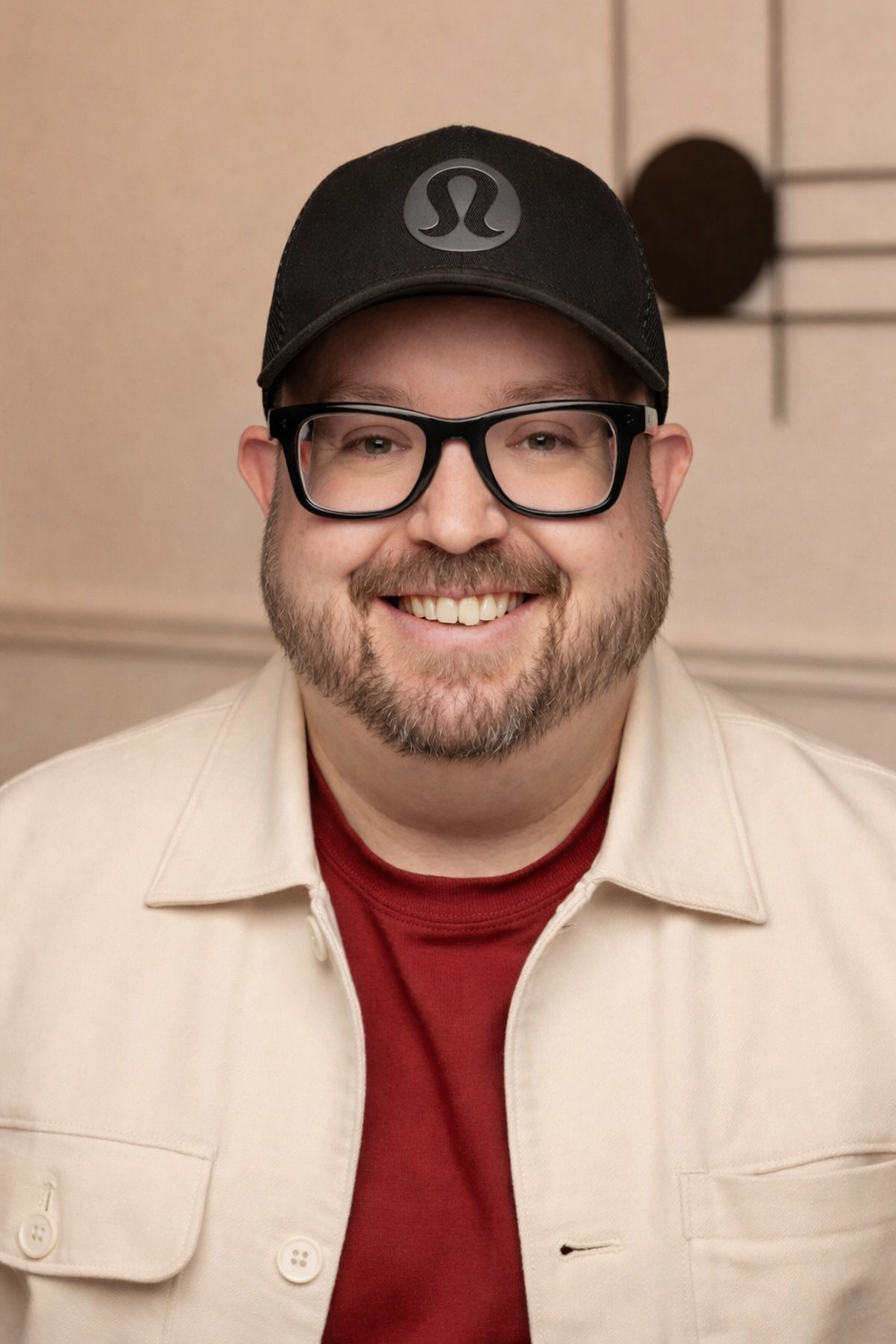 A middle-aged man with glasses, a beard, and a mustache, wearing a green sweatshirt, looking into the camera smiling