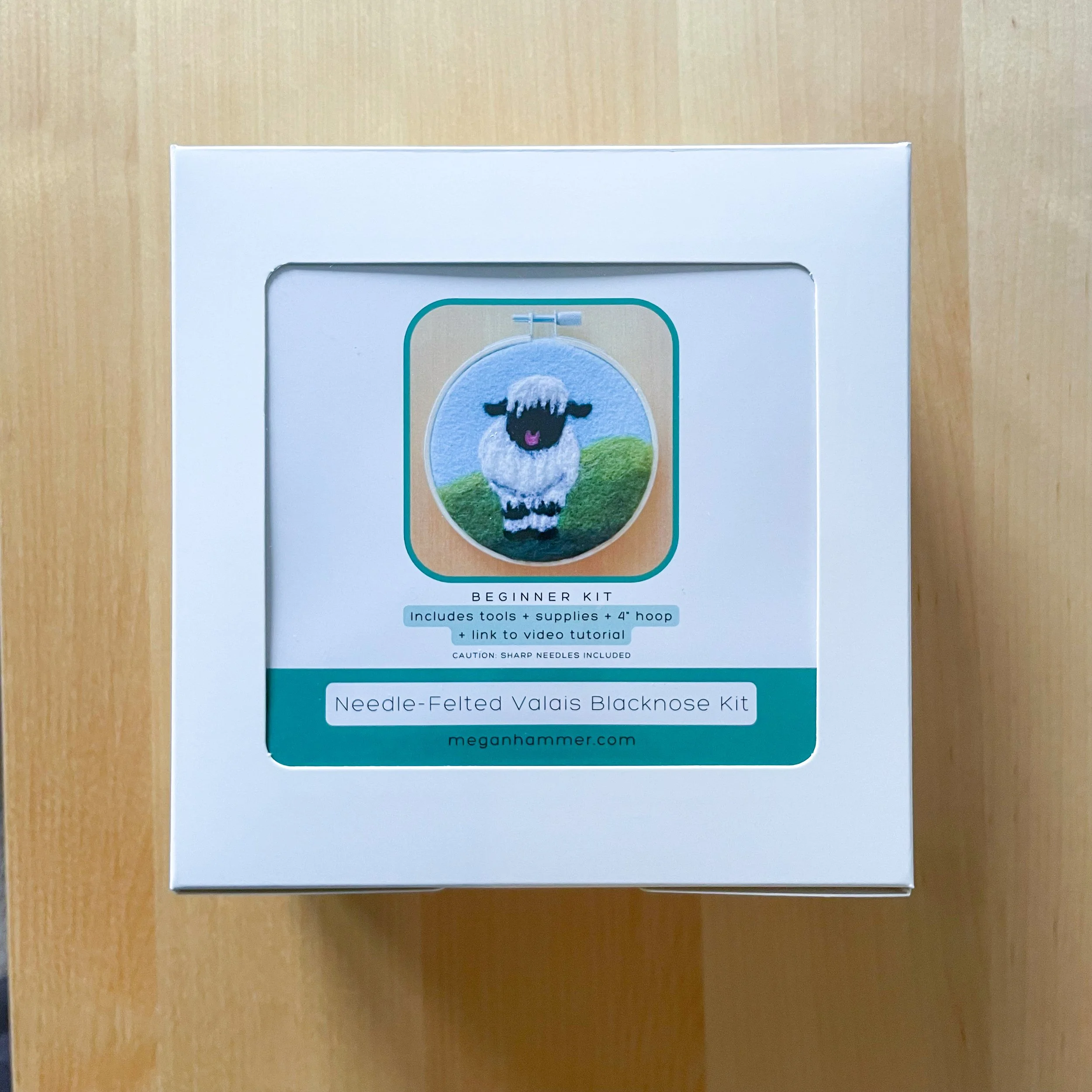 White box labeled Needle-Felted Valais Blacknose Sheep Kit, showing a picture of felted art framed in an embroidery hoop.