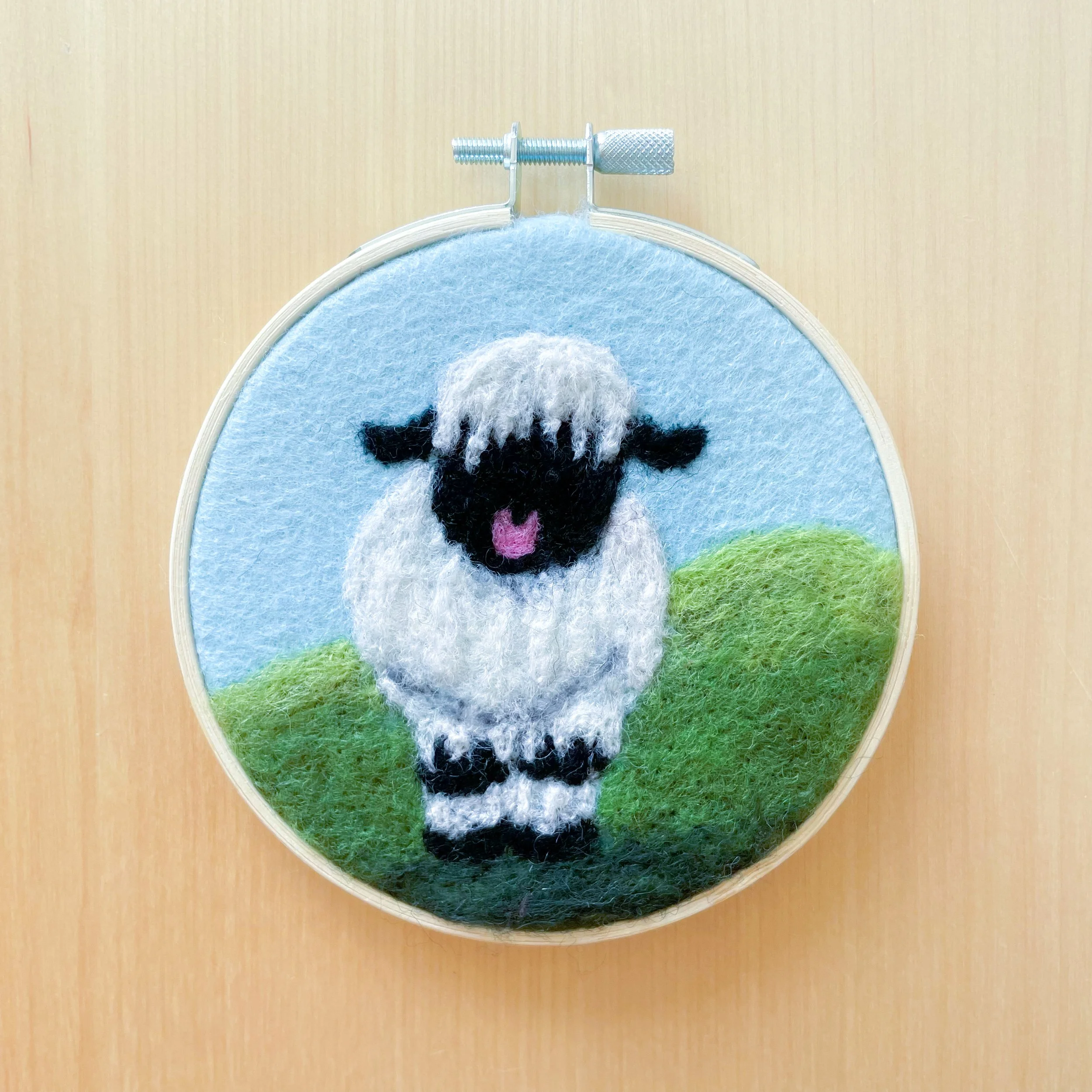 Felted Valais Blacknose Sheep art framed in an embroidery hoop.
