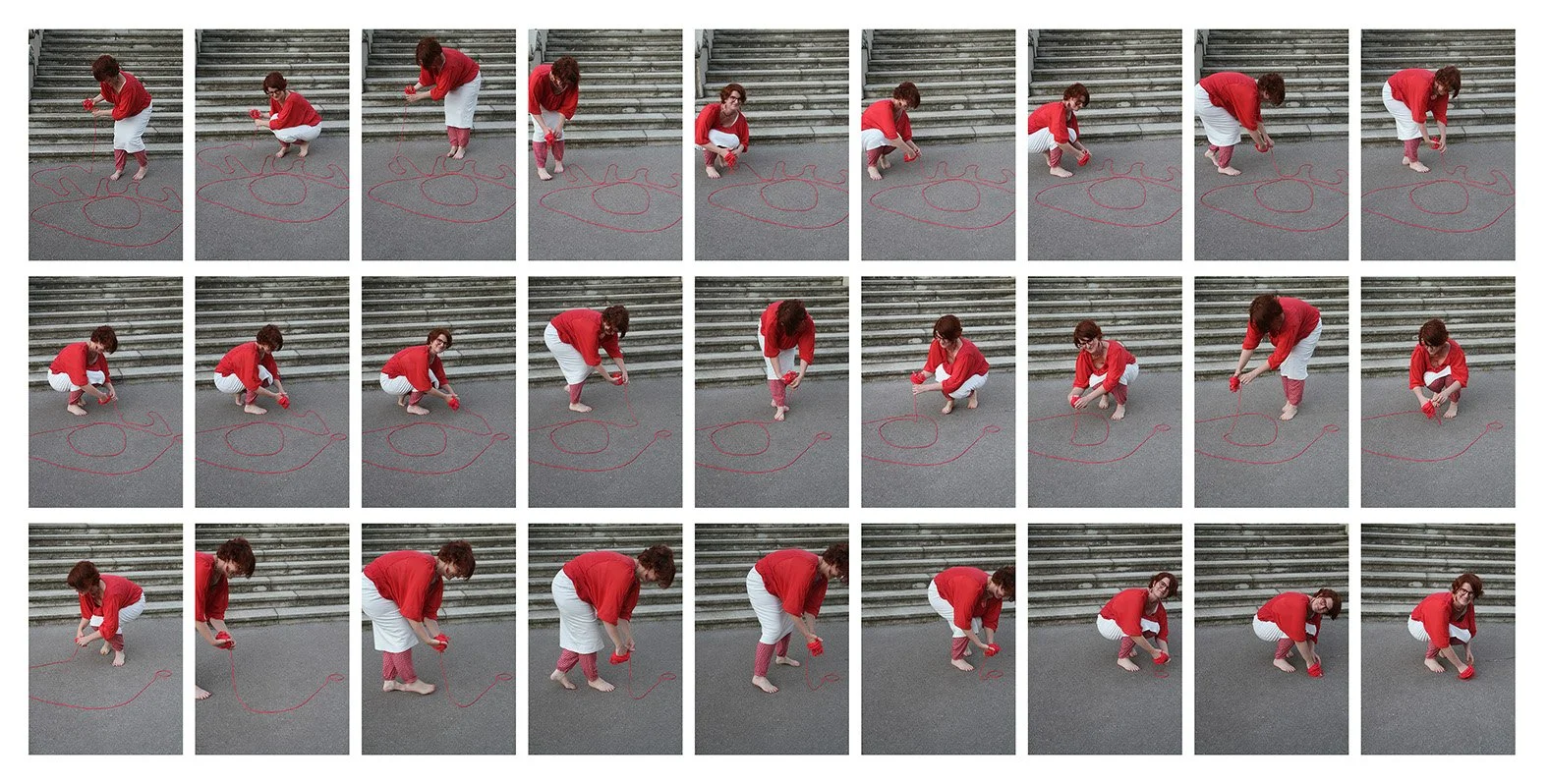 A woman in a red shirt, white skirt, and red and pink striped leggings is drawing a large Christmas tree on the ground with red chalk, while kneeling or squatting on outdoor stairs.
