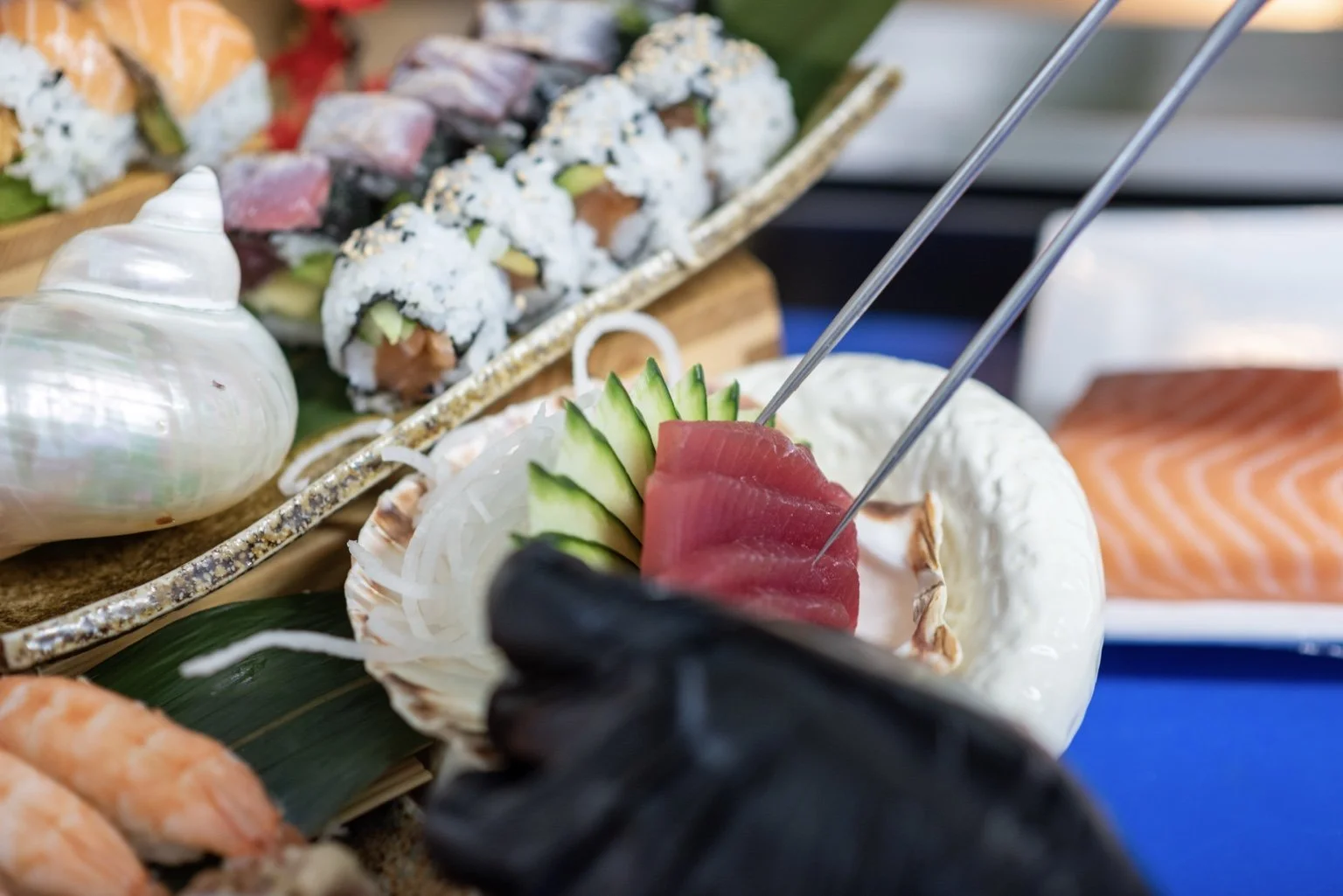 Sushi chef plating fresh tuna sashimi and handcrafted sushi.