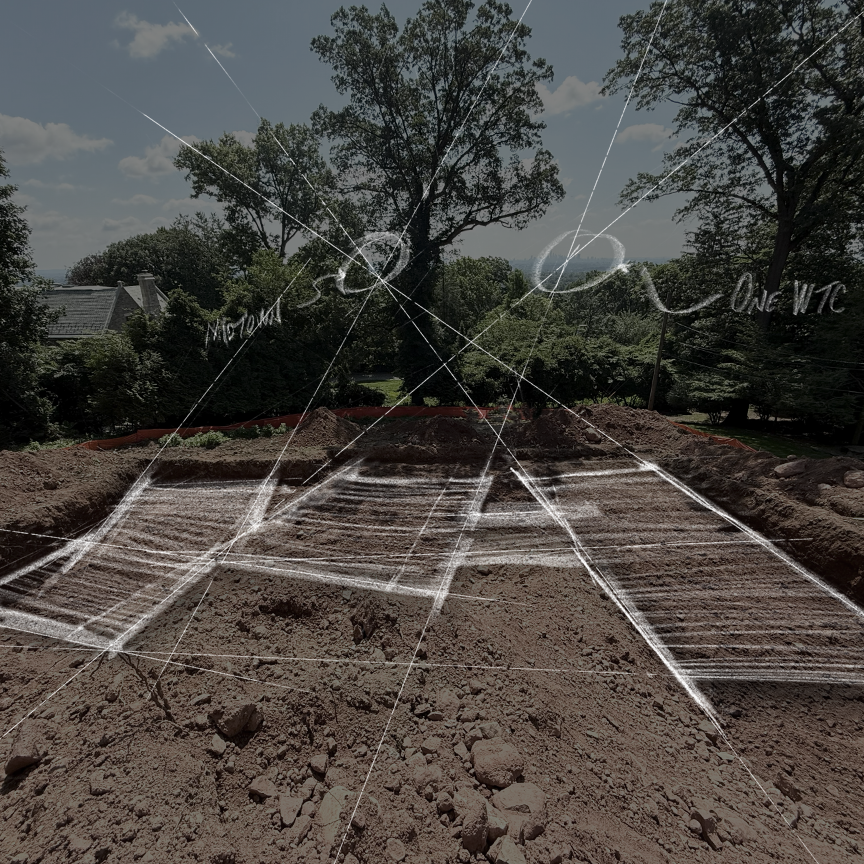 Construction site with marked boundaries and measuring lines, surrounded by trees and residential houses in the background.
