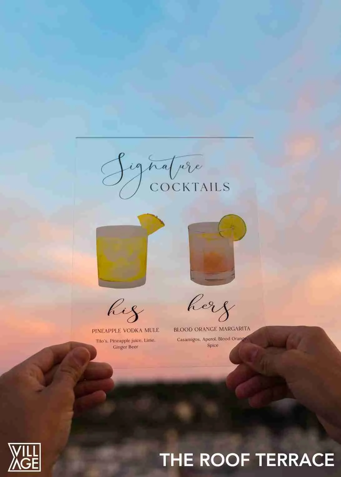 Sign advertising signature cocktails with images of two drinks; one lemon wedge garnish on a yellow drink labeled 'his' Pineapple Vodka Mule, and a lemon slice garnish on a pink drink labeled 'hers' Blood Orange Margarita, held against a sunset sky b