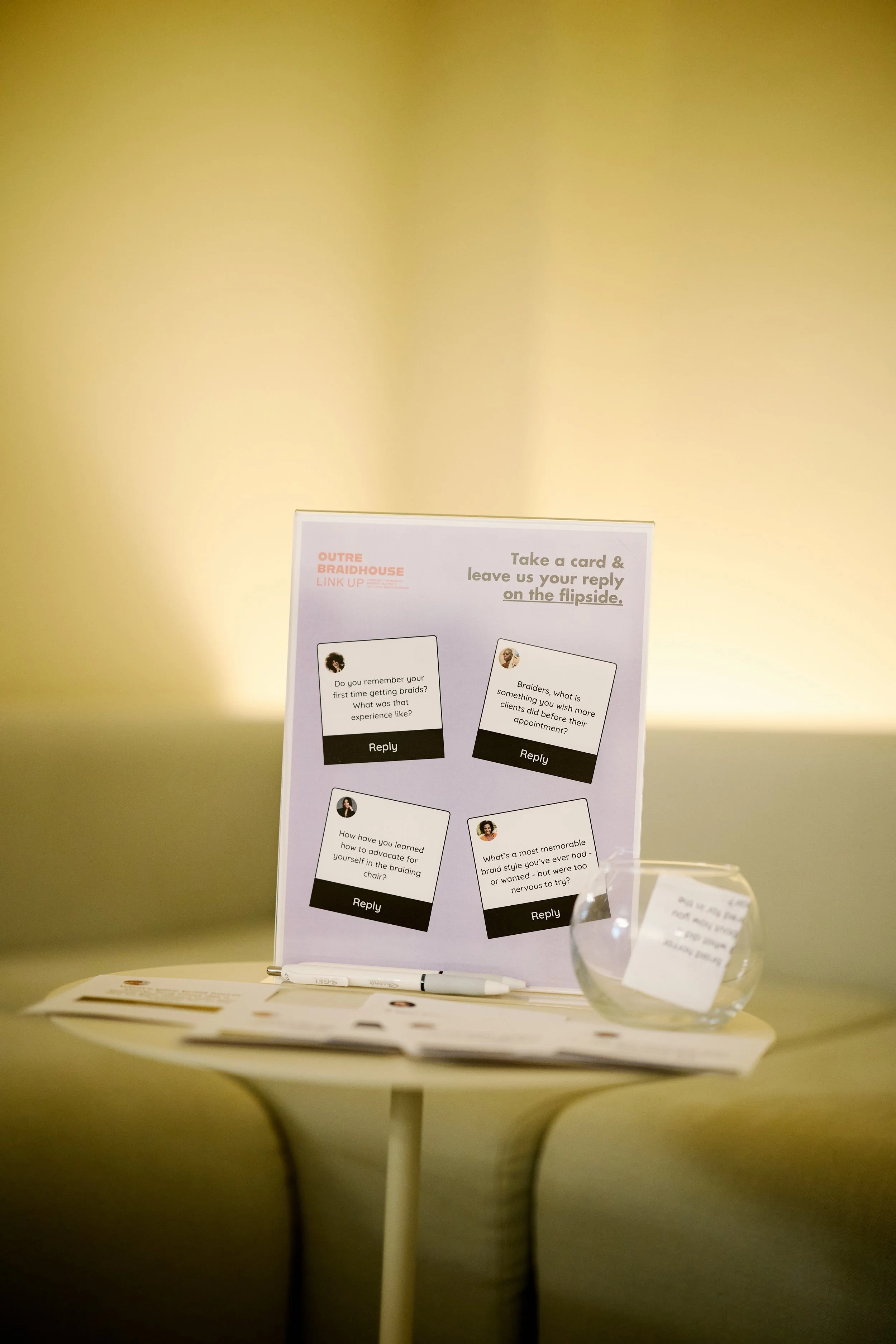 Sign with instructions and questions for attendees to respond on a flipside. The sign includes four questions about braids and a reply section.