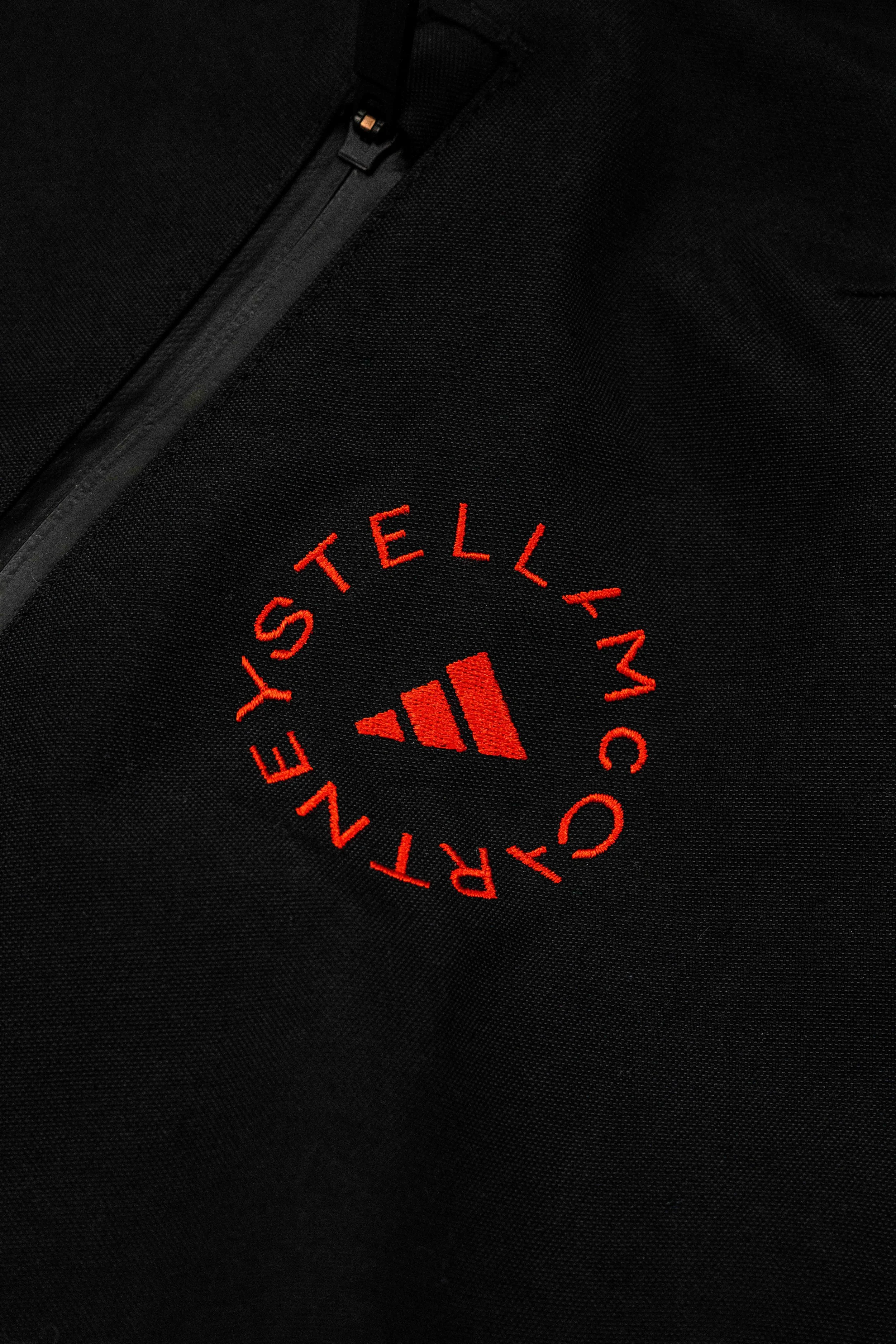 Close-up of a black Nike athletic jacket with red embroidery showing the text "CARY STELLAR MCCARTHY" in a circular pattern around the Nike logo.