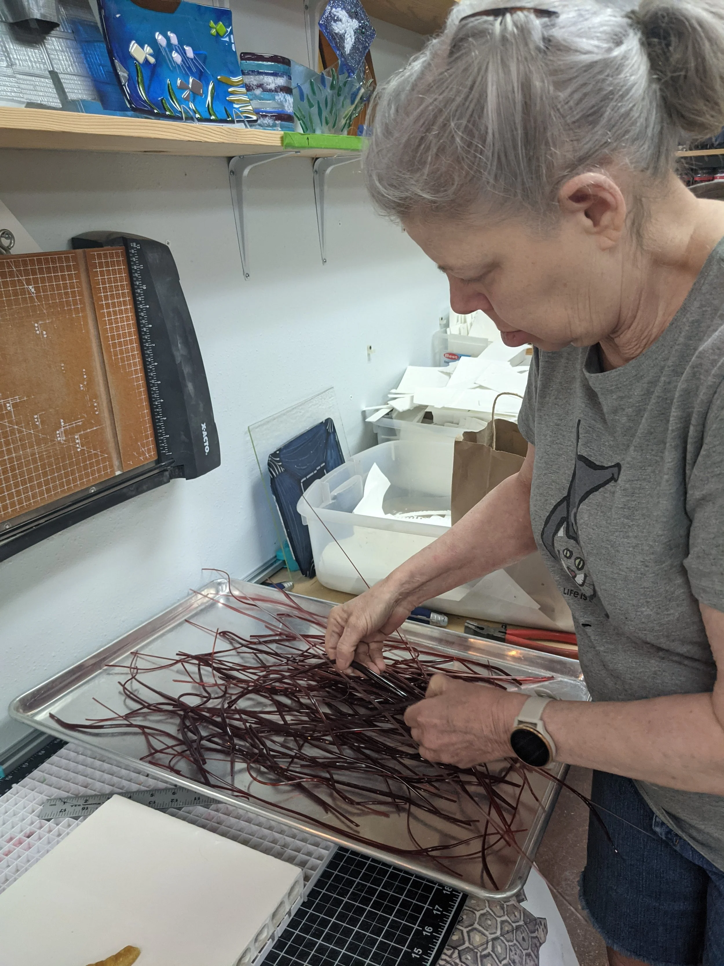 Laurie Rich inspecting her vitrigraph pulls, which are soon to become coral veins!