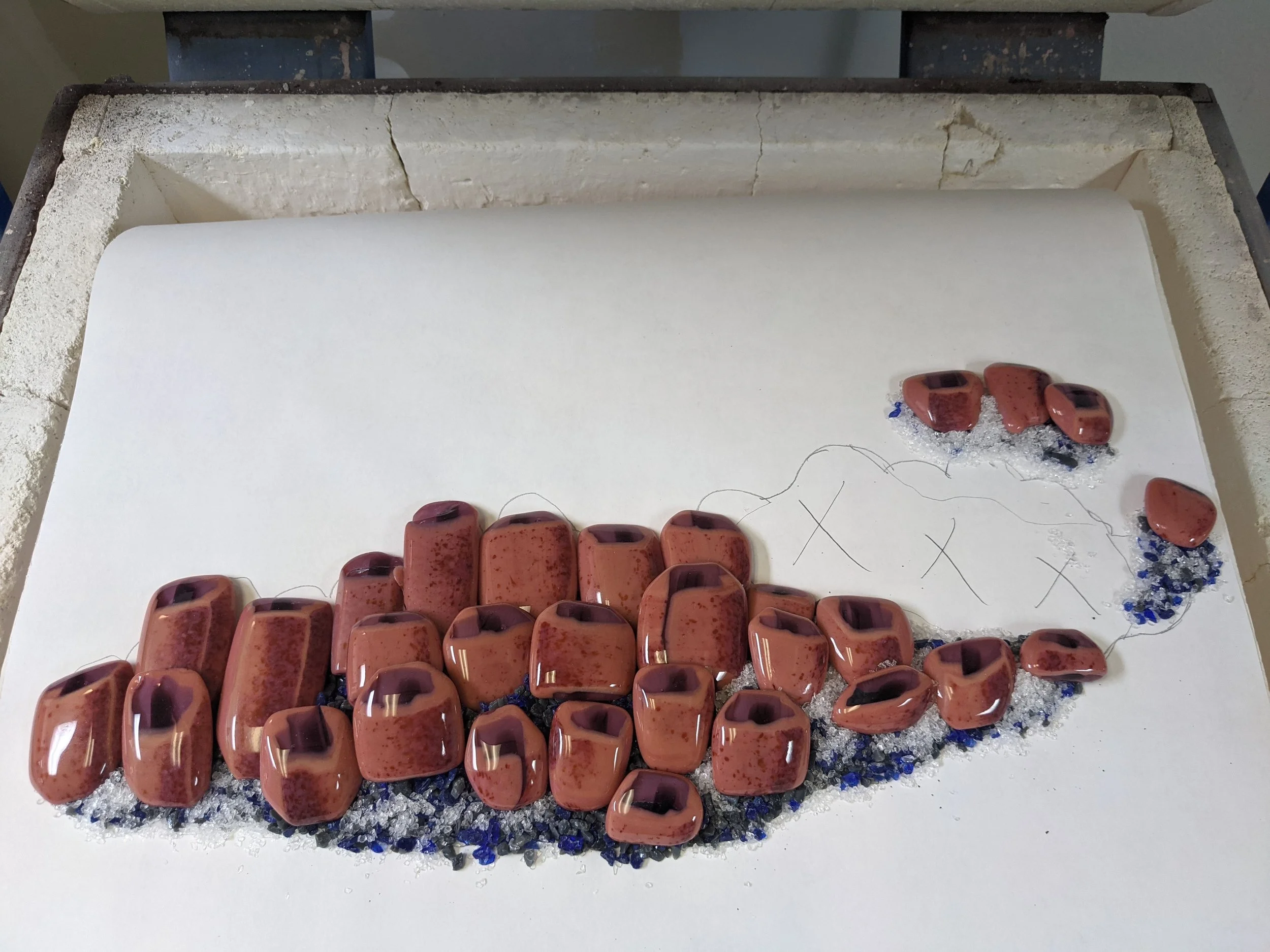 After being fired and cut, Kristine laid the tubeworms on a bed of frit for their final trip through the kiln.