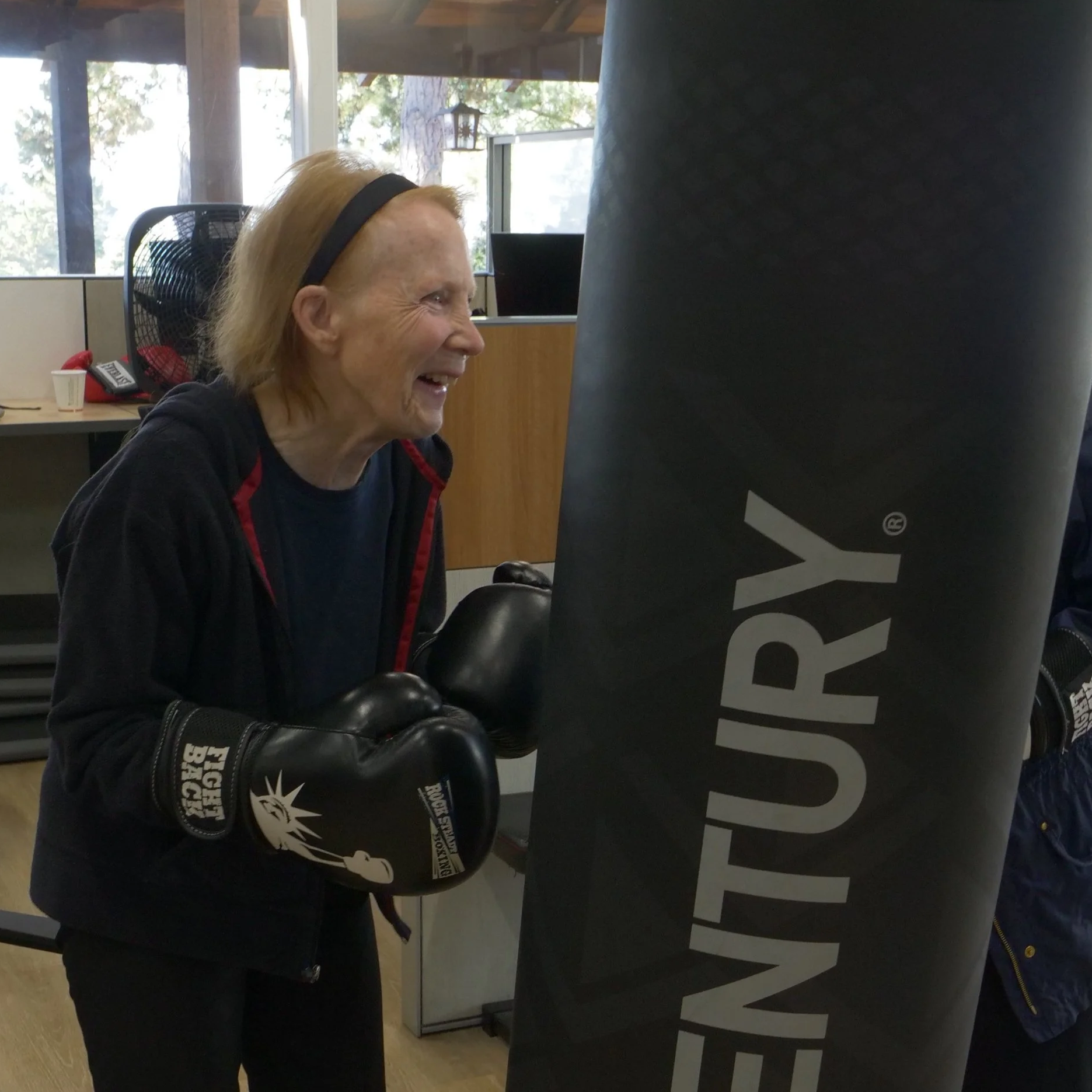 A woman punches a boxing bag in an exercise studio
