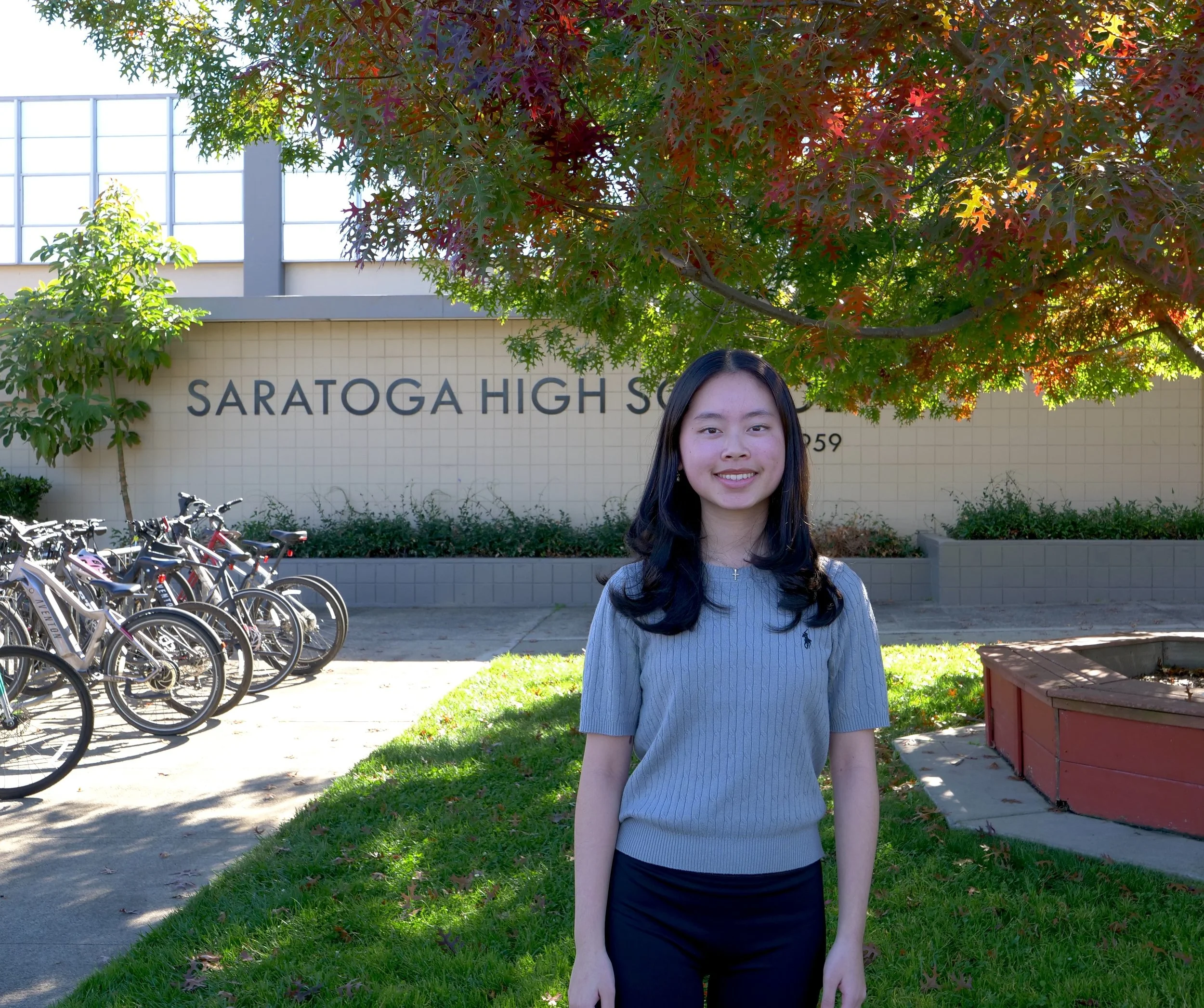 Lucy Zhang stands in front of Saratoga High School