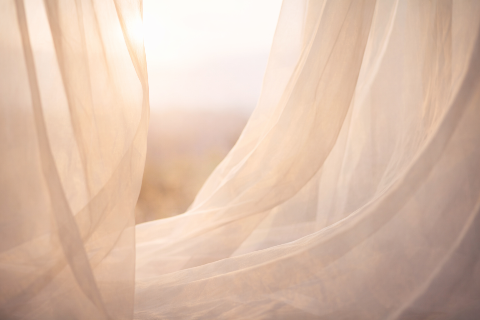 Sheer fabric in warm light symbolizing awareness and the soft expansion of conscious identity