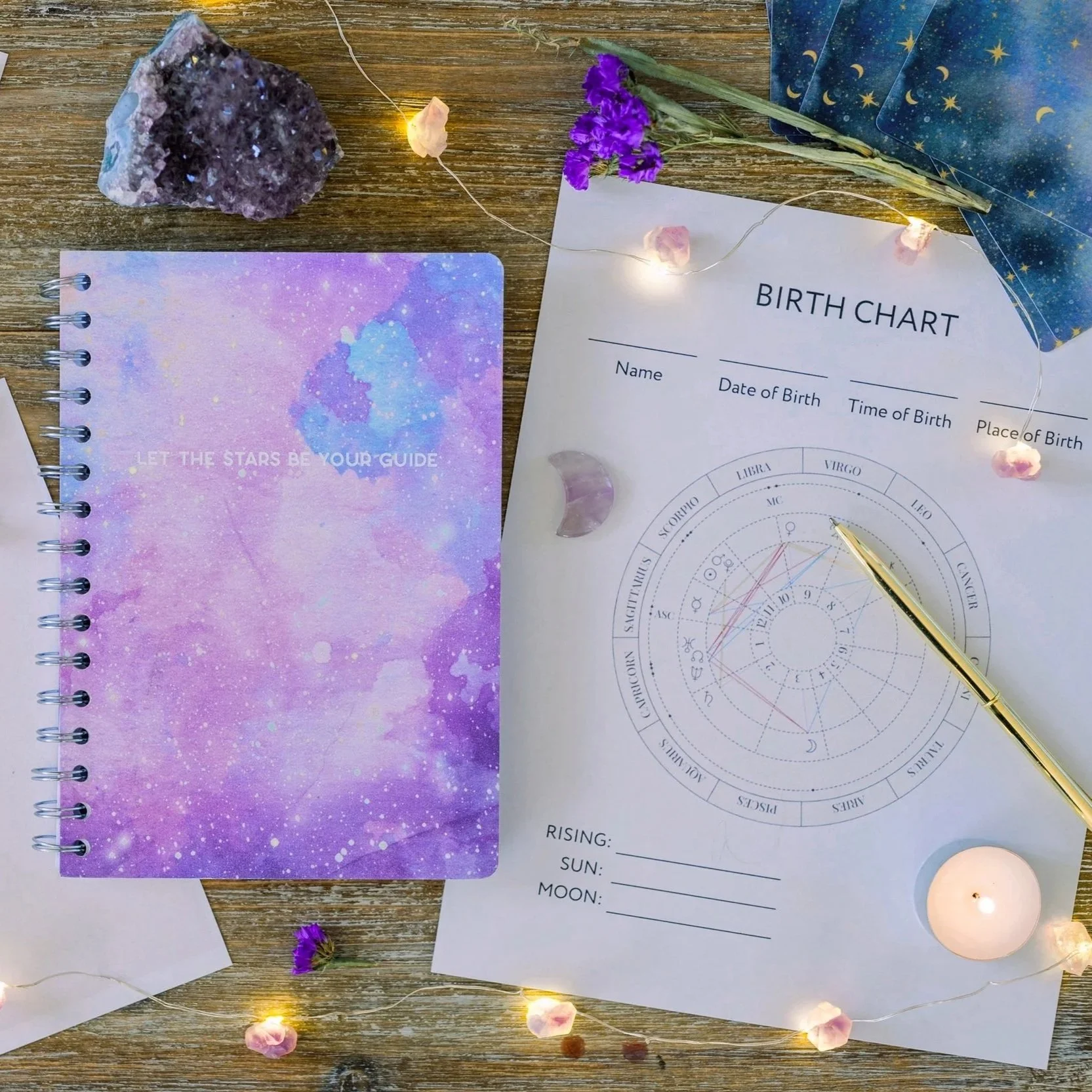 Astrological chart template with gold pin, string lights, and notebook with cover text "Let the stars be your guide.", representing astrological insights and clear guidance.