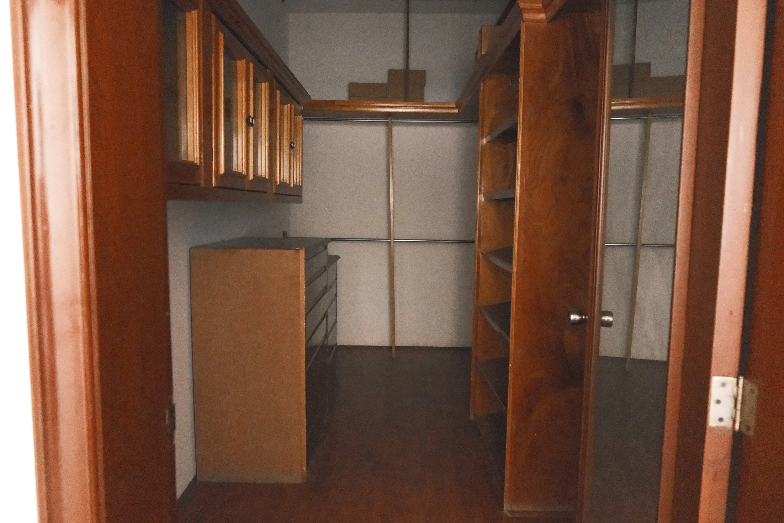 Armario de madera vacío con estantes y gavetas en una habitación de almacenamiento