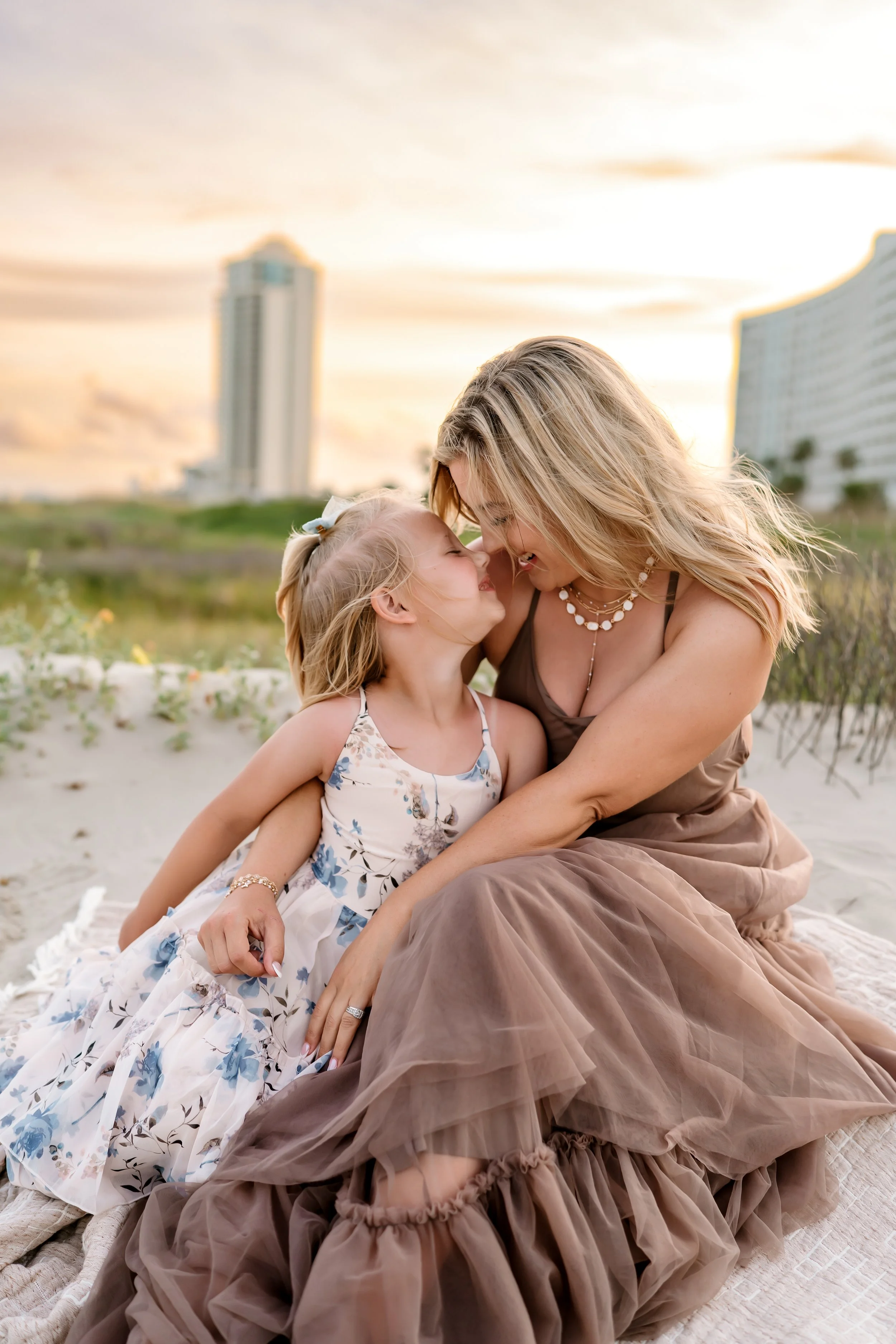 Mother and young daughter sharing a quiet moment together during a motherhood photography session in Galveston, TX