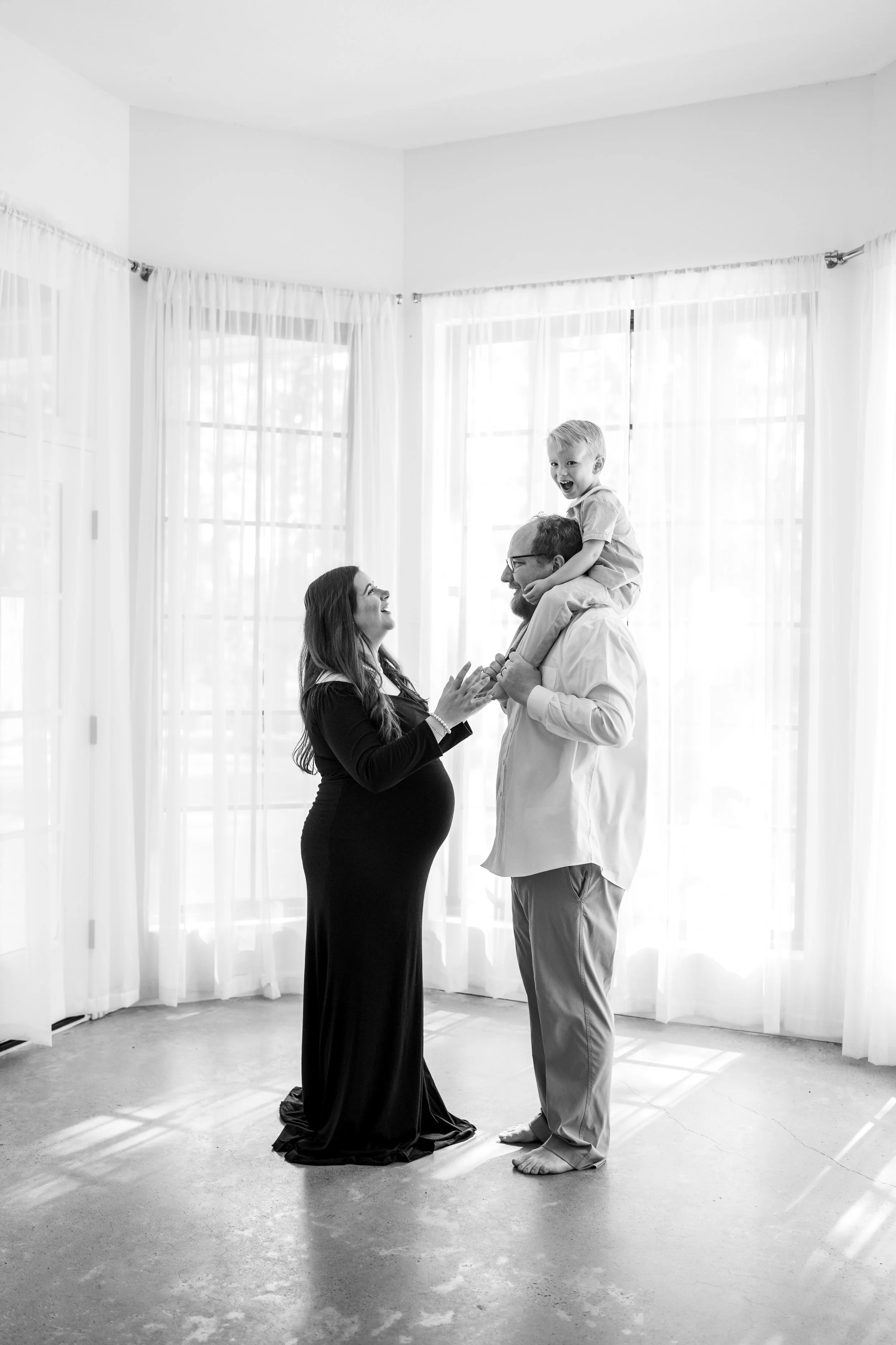 Pregnant couple embracing during a natural light maternity photography session in The Woodlands, TX