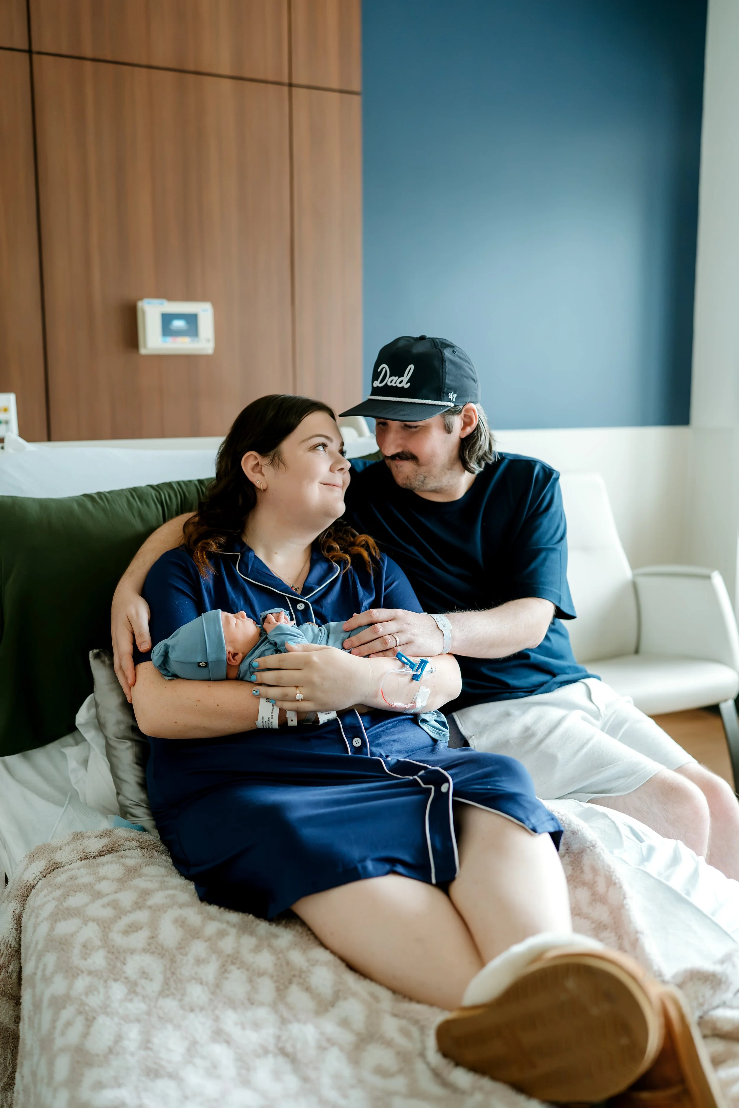 couple holding their baby boy in hospital with fresh 48 photographer in the Woodlands tx