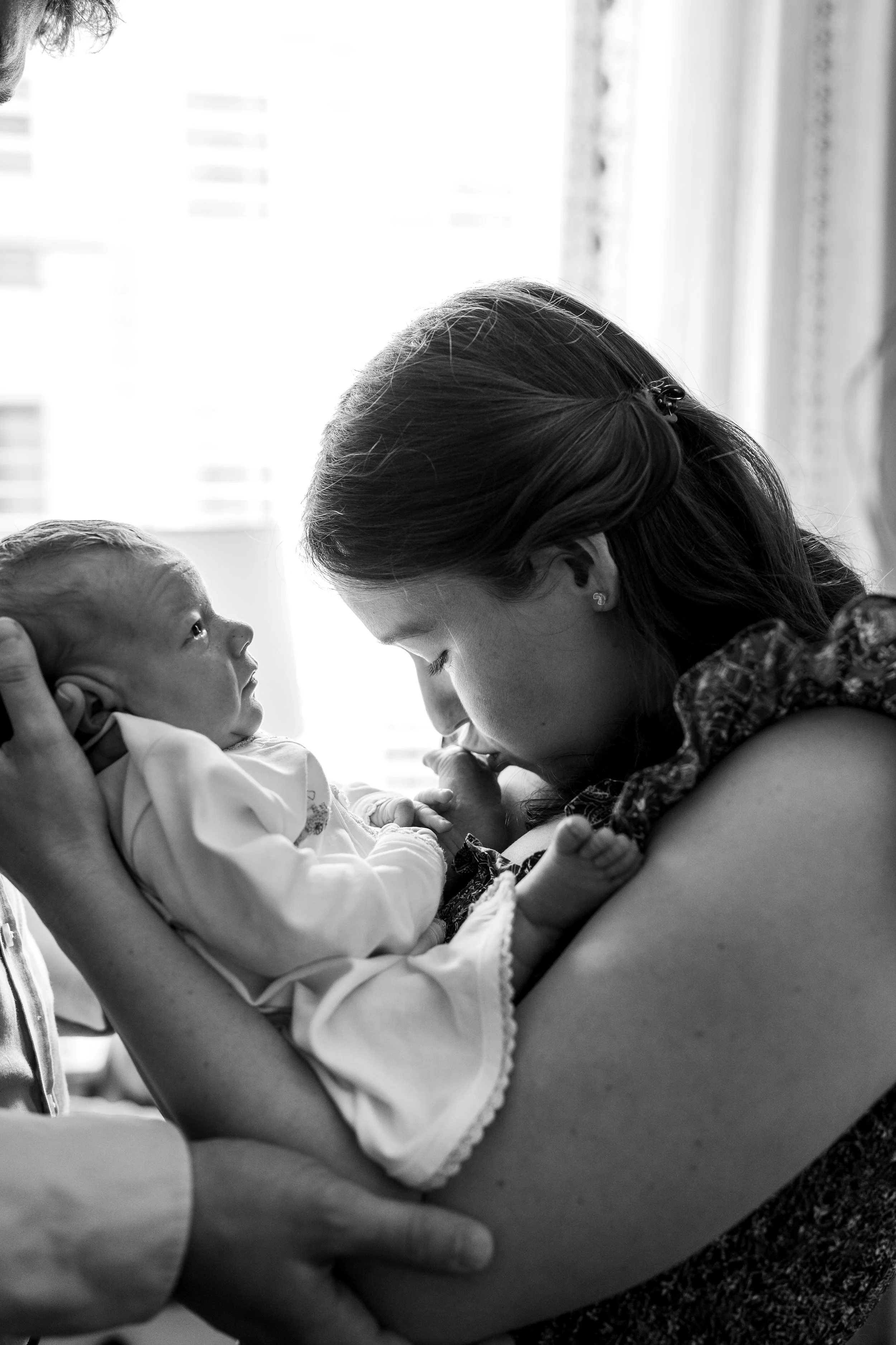 Mother holding her newborn baby and sharing a quiet moment together during a newborn photography session in The Woodlands, TX