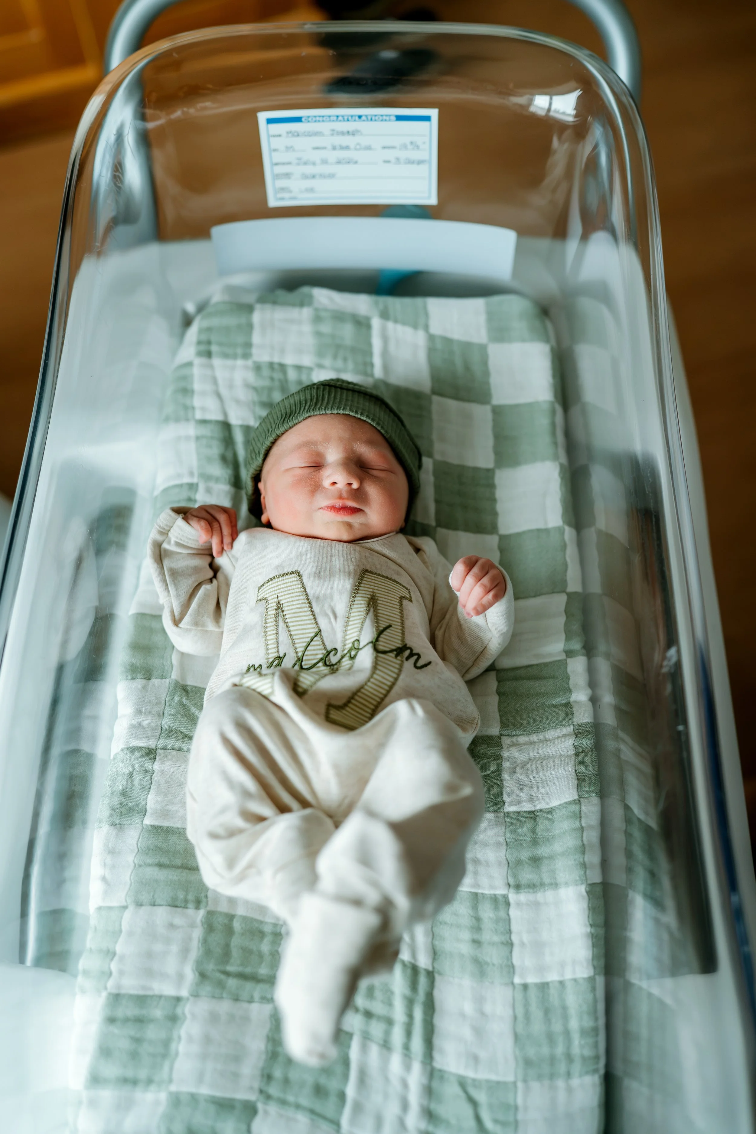 Newborn baby resting in a hospital bassinet during a Fresh 48 photography session in The Woodlands, TX