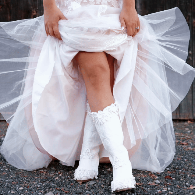 Wedding Videographer in NH. Bride lifting her wedding dress to show her white stocking and leg. Wedding Venue in NH, people having fun, wedding traditions. 