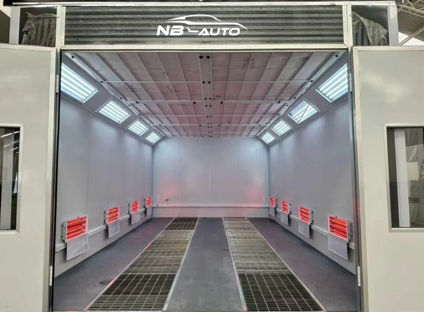 Innenraum einer Autolackierkabine mit Belüftungs- und Heizsystemen.