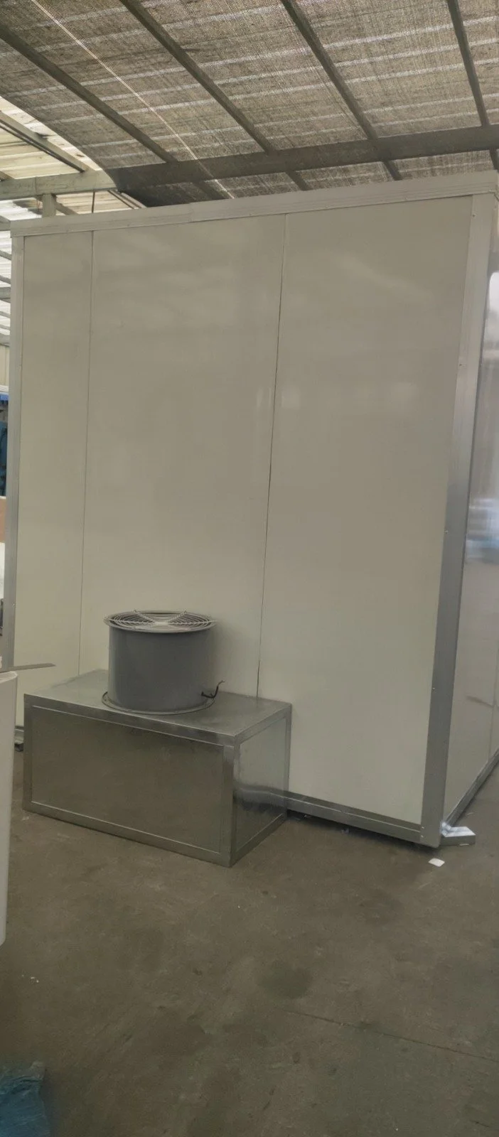Ein weißer, temperierter Raum mit Metallwänden und einem Lüfter auf einem Metallblock.