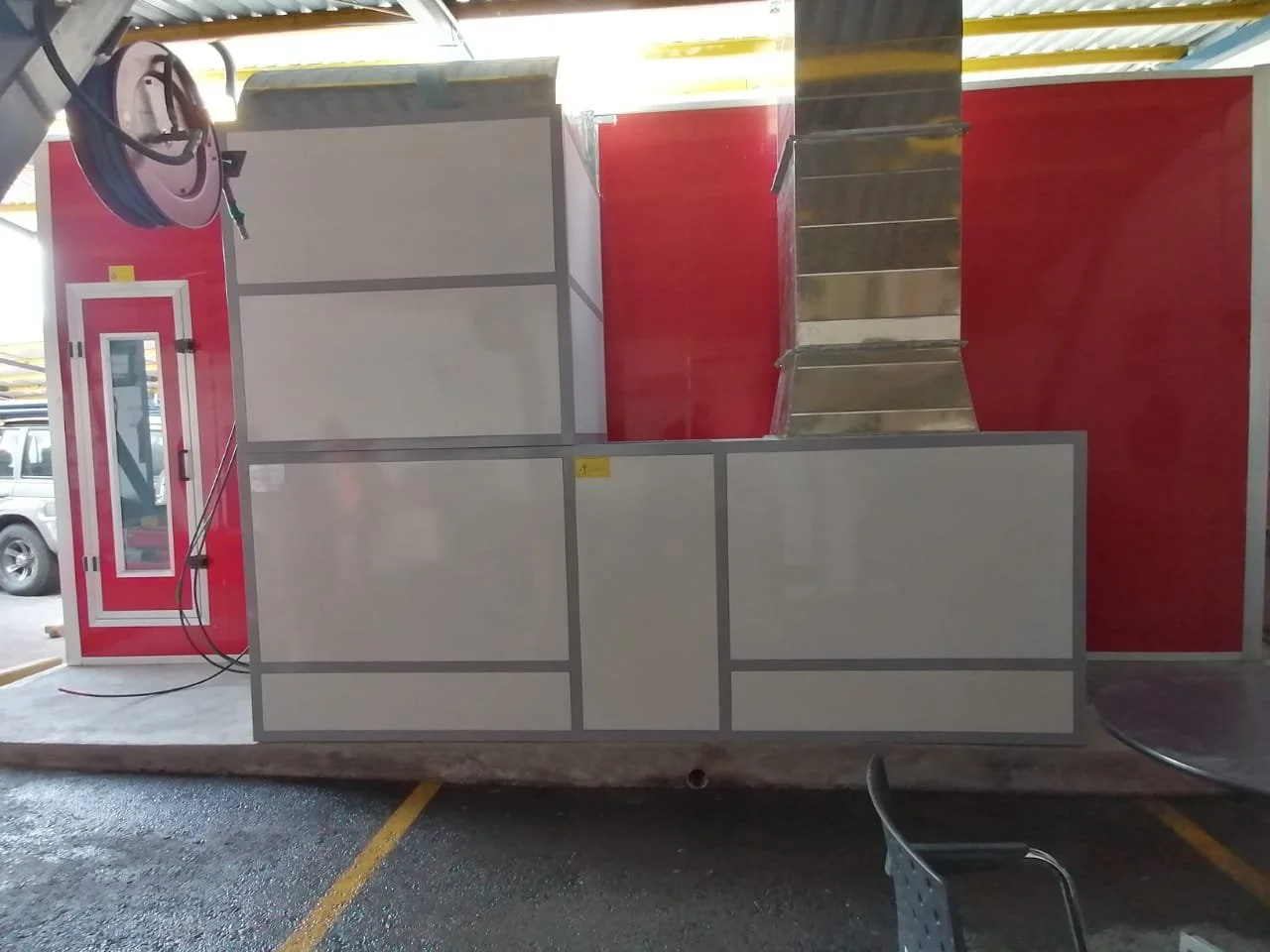 Der Blick auf einen mobilen Verkaufswagen mit rotem und weißen Paneelen, einer Treppe und einem Reifen an der Seite.