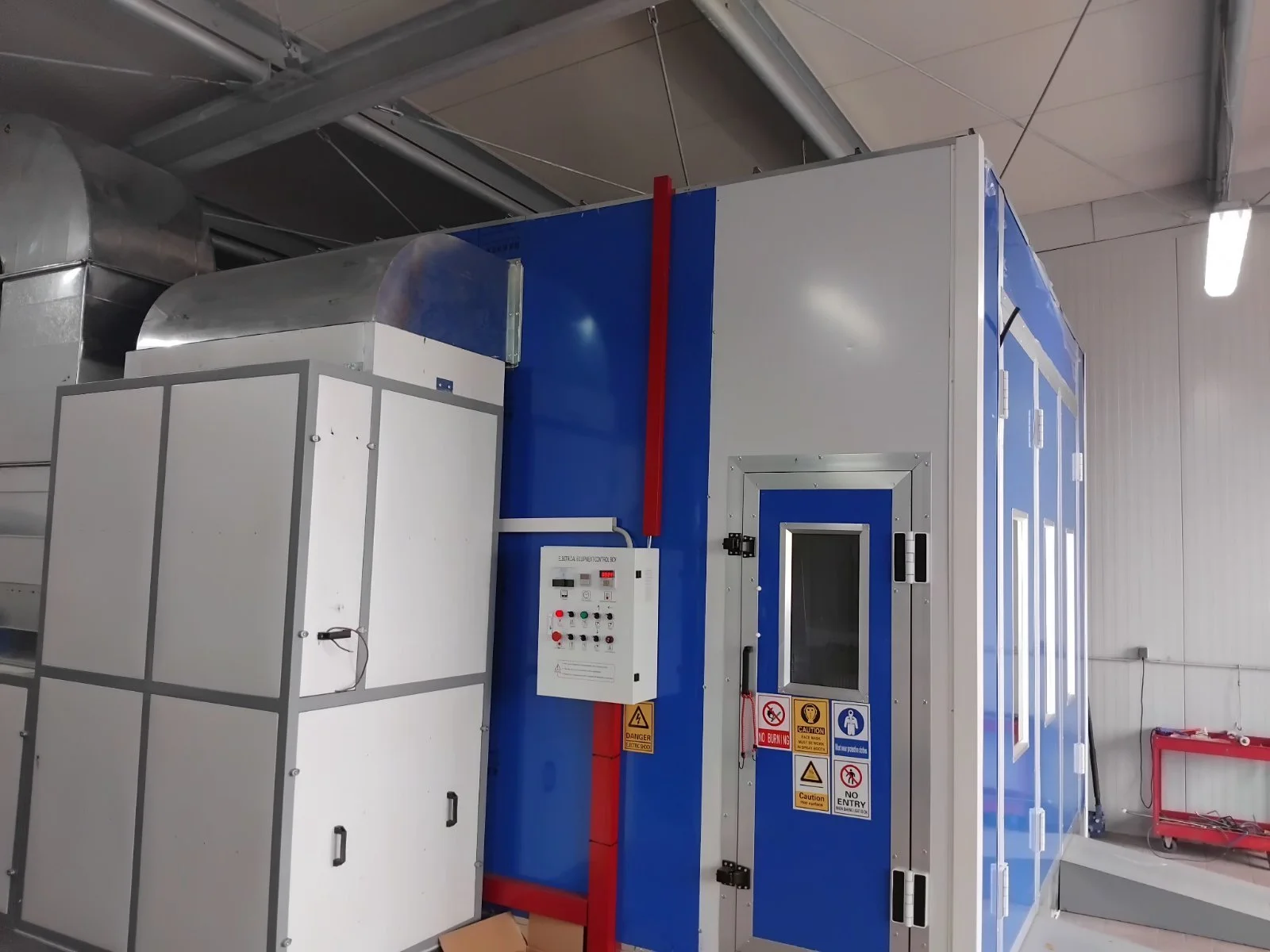 Großer blauer und weißer technischer Raum mit Anlage, Kontrolltafel und Warnhinweisen