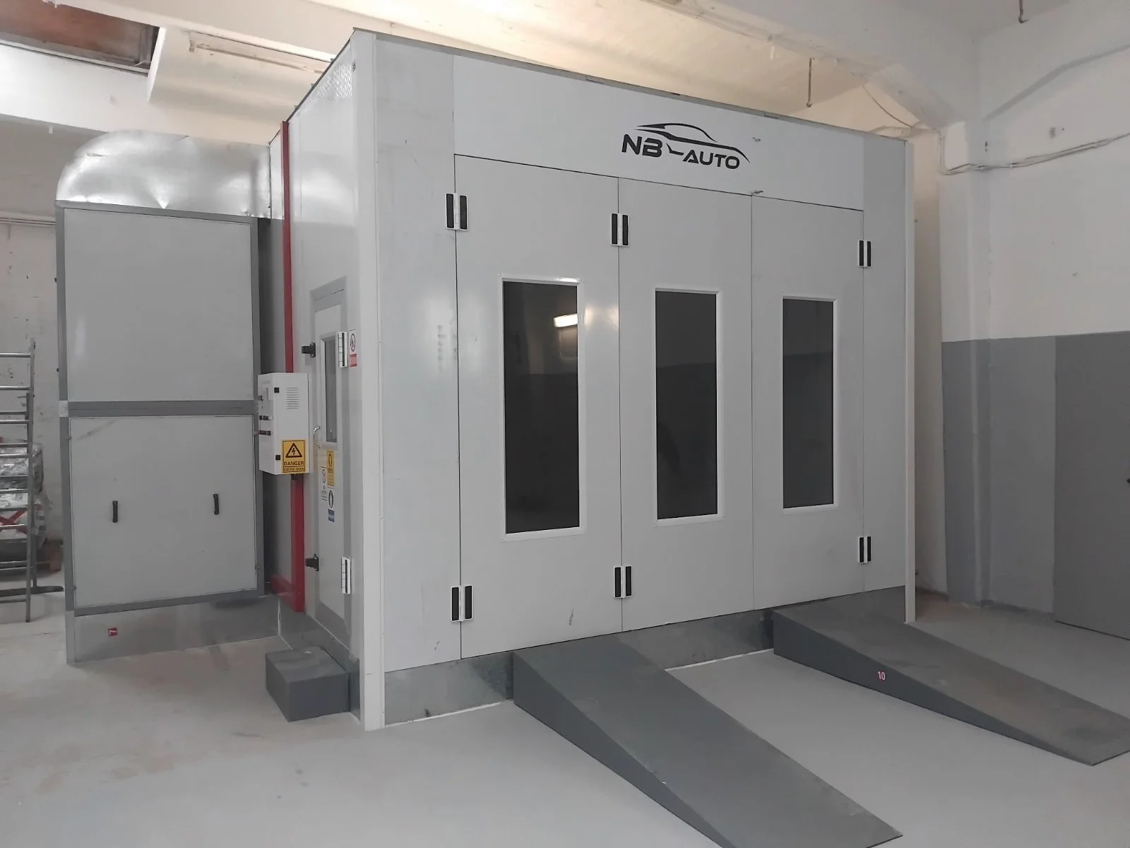 Automobil-Reinigungszelle mit Oberlicht, Beschriftung NB AUTO, in einer Garage oder Werkstatt