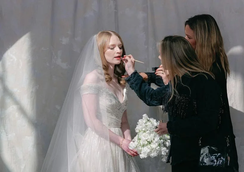 Bride getting hair and makeup touch-ups.