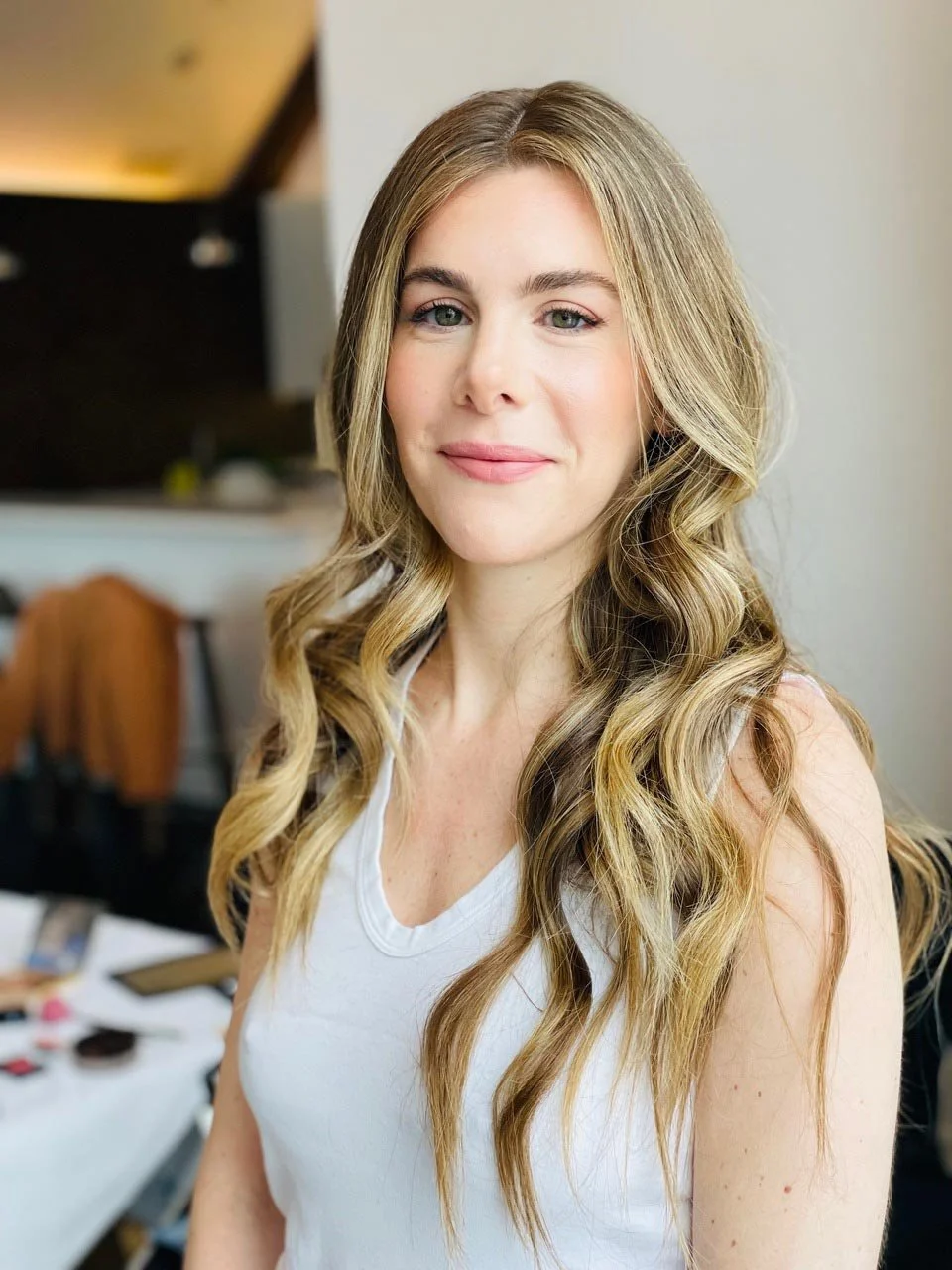 Smiling woman who just had her hair styled in long, natural waves.