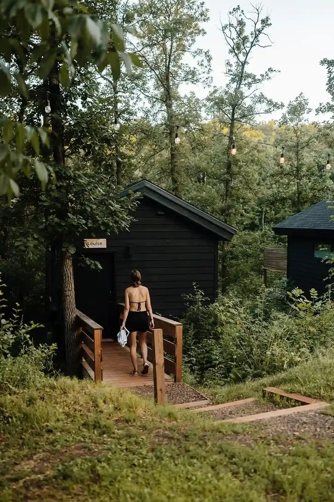 Guest entering Louise Cabin at Cuyuna Cove, a modern boutique hotel cabin stay in the forest in Crosby Minnesota near the Cuyuna bike trails